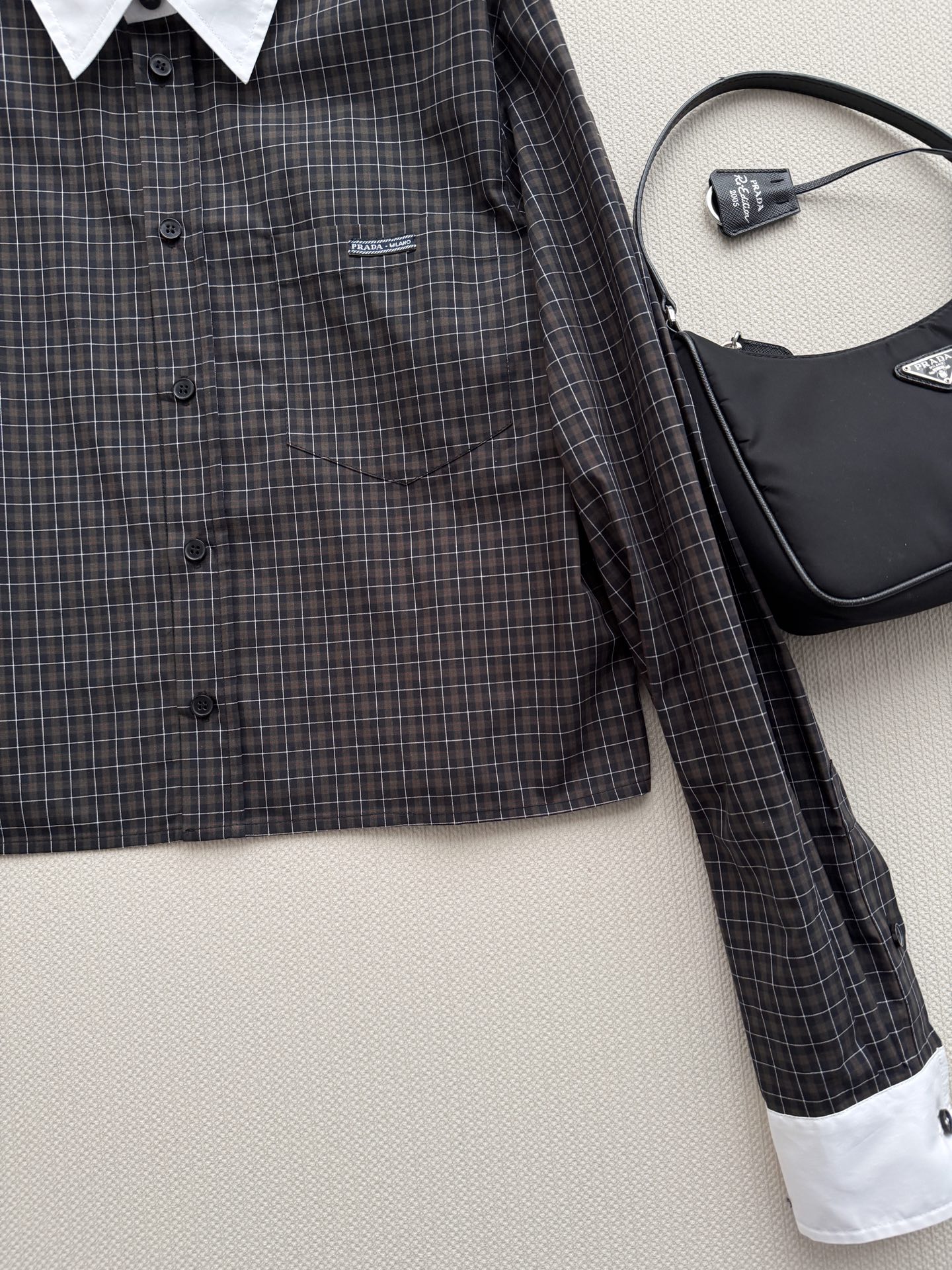 Prad*🆕新款衬衫，短款衬衫，深色底配白色细格纹，白色翻领和袖口做撞色拼接，左胸有小 logo 刺绣，短款箱型剪裁，拉