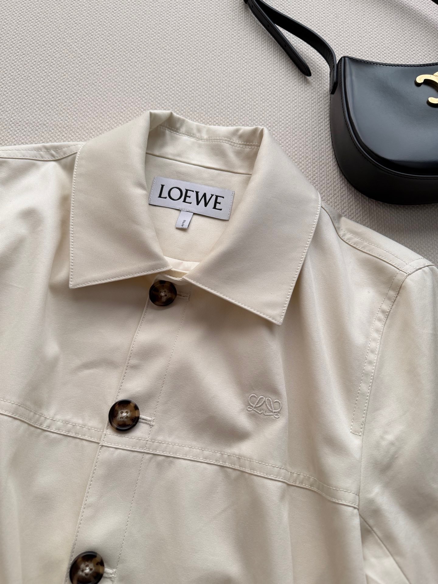 Loew*🆕米白色棉丝混纺面料，翻领短款剪裁，门襟排列深棕色木纹纽扣，前片两条贴袋，袖口翻折设计。整体版型带一点气球廓形