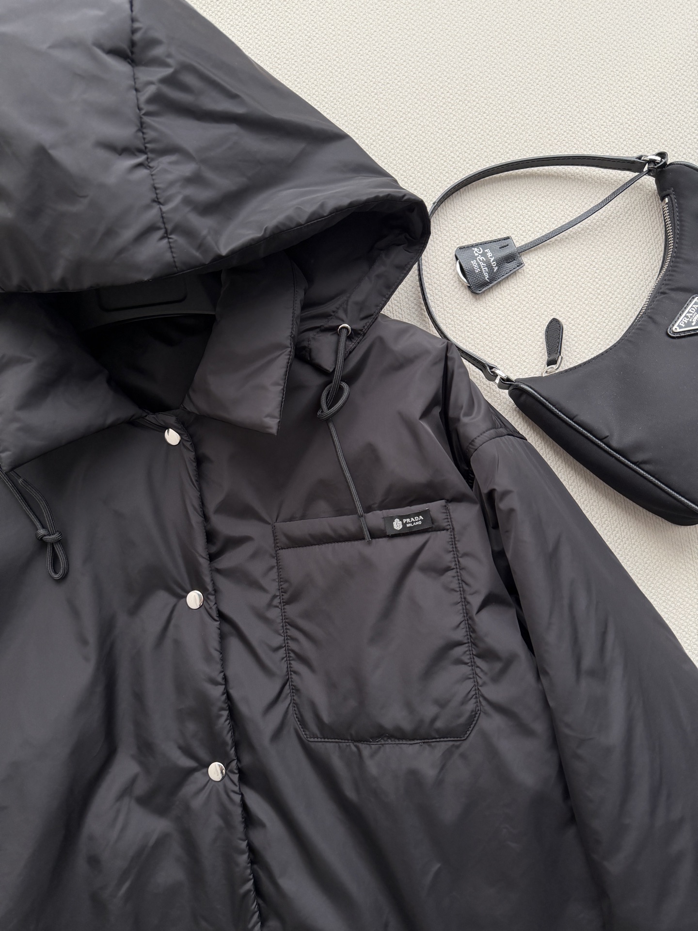 Prad*🆕这款短夹克以极简方式诠释实用机能，采用轻盈Re-Nylon（再生尼龙）面料打造，设计利落流畅。此款造型以轻盈