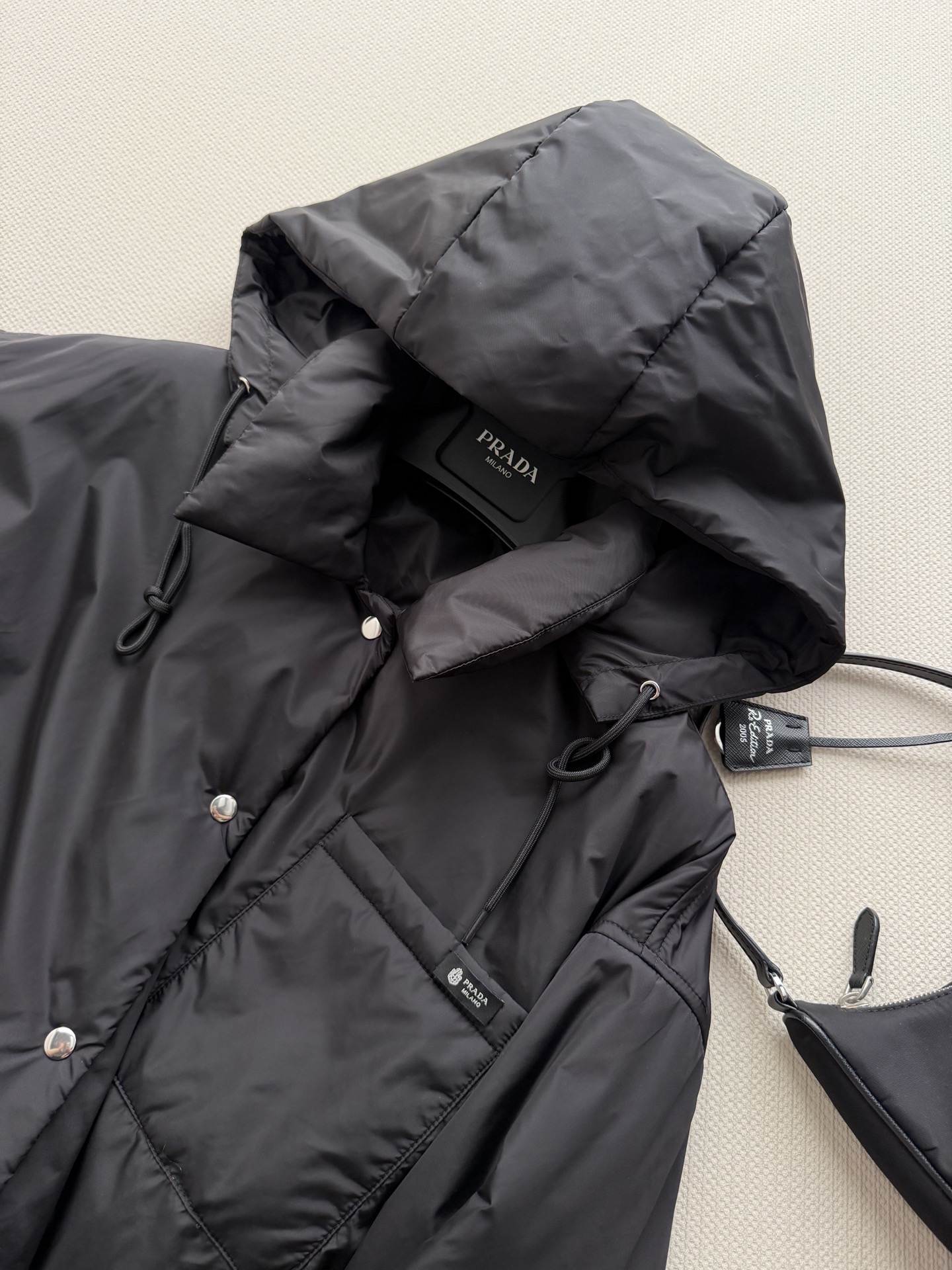 Prad*🆕这款短夹克以极简方式诠释实用机能，采用轻盈Re-Nylon（再生尼龙）面料打造，设计利落流畅。此款造型以轻盈