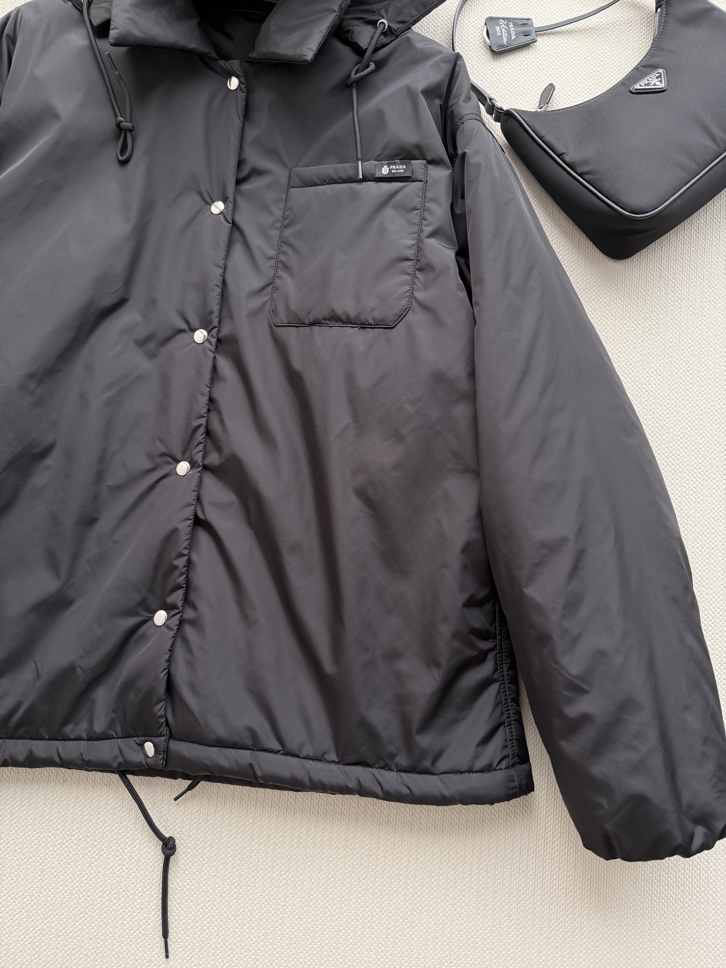 Prad*🆕这款短夹克以极简方式诠释实用机能，采用轻盈Re-Nylon（再生尼龙）面料打造，设计利落流畅。此款造型以轻盈