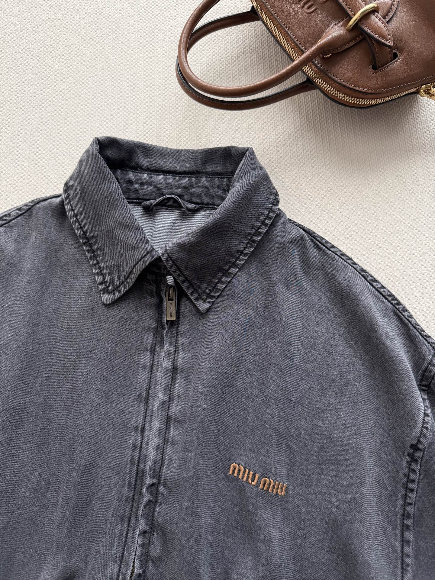 Miu Mi*🆕工装夹克的酷感与精致 「当复古水洗灰遇上标志性金标，这件夹克把街头酷感与品牌精致缝进每一寸丹宁肌理」 深