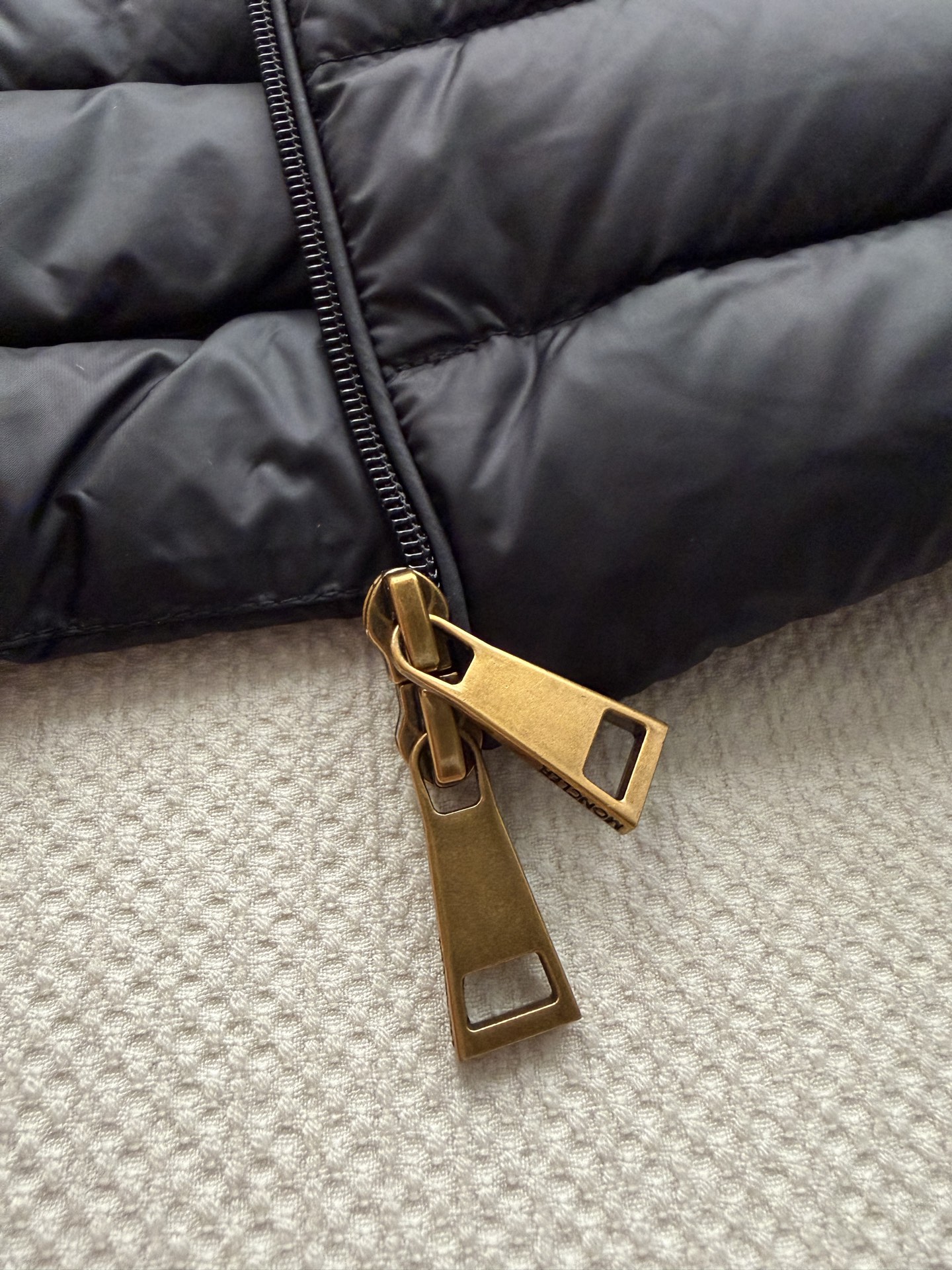 Moncle*🆕排骨款羽绒服，细密横向绗缝，轻薄贴身不臃肿。连帽设计，前襟拉链开合，金色拉链头做点缀。左臂有经典的 Mo