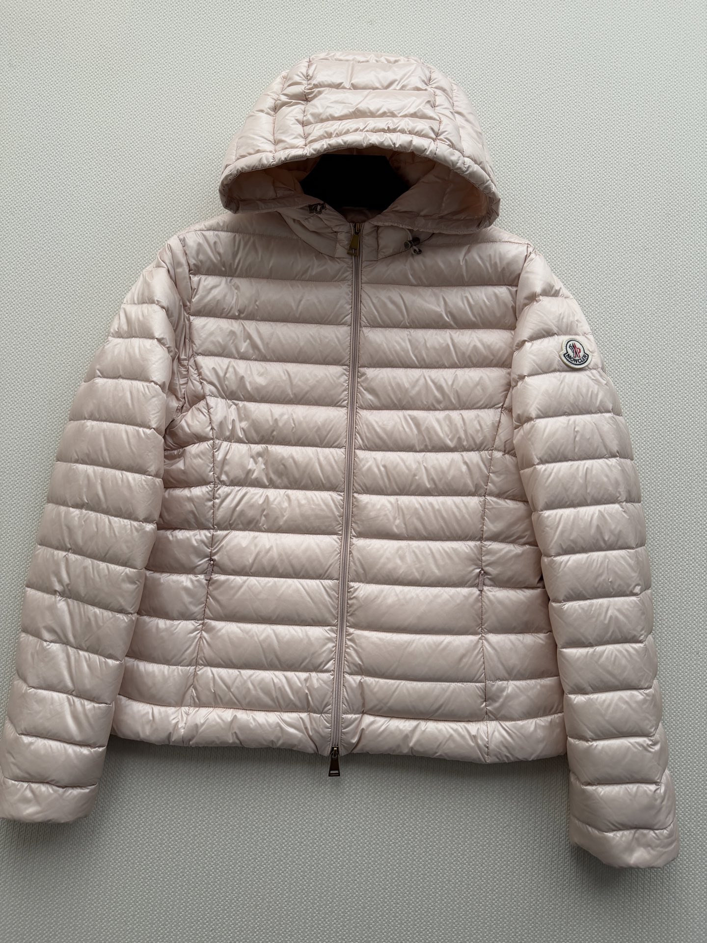 Moncle*🆕排骨款羽绒服，细密横向绗缝，轻薄贴身不臃肿。连帽设计，前襟拉链开合，金色拉链头做点缀。左臂有经典的 Mo