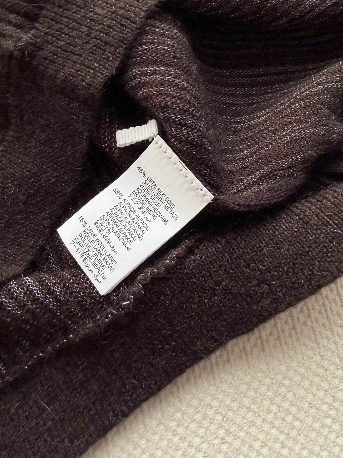 Brunello Cucinelli 的炭灰色细闪坑条针织开衫​​，——没有 logo，全靠面料和剪裁说话。 炭灰色（接