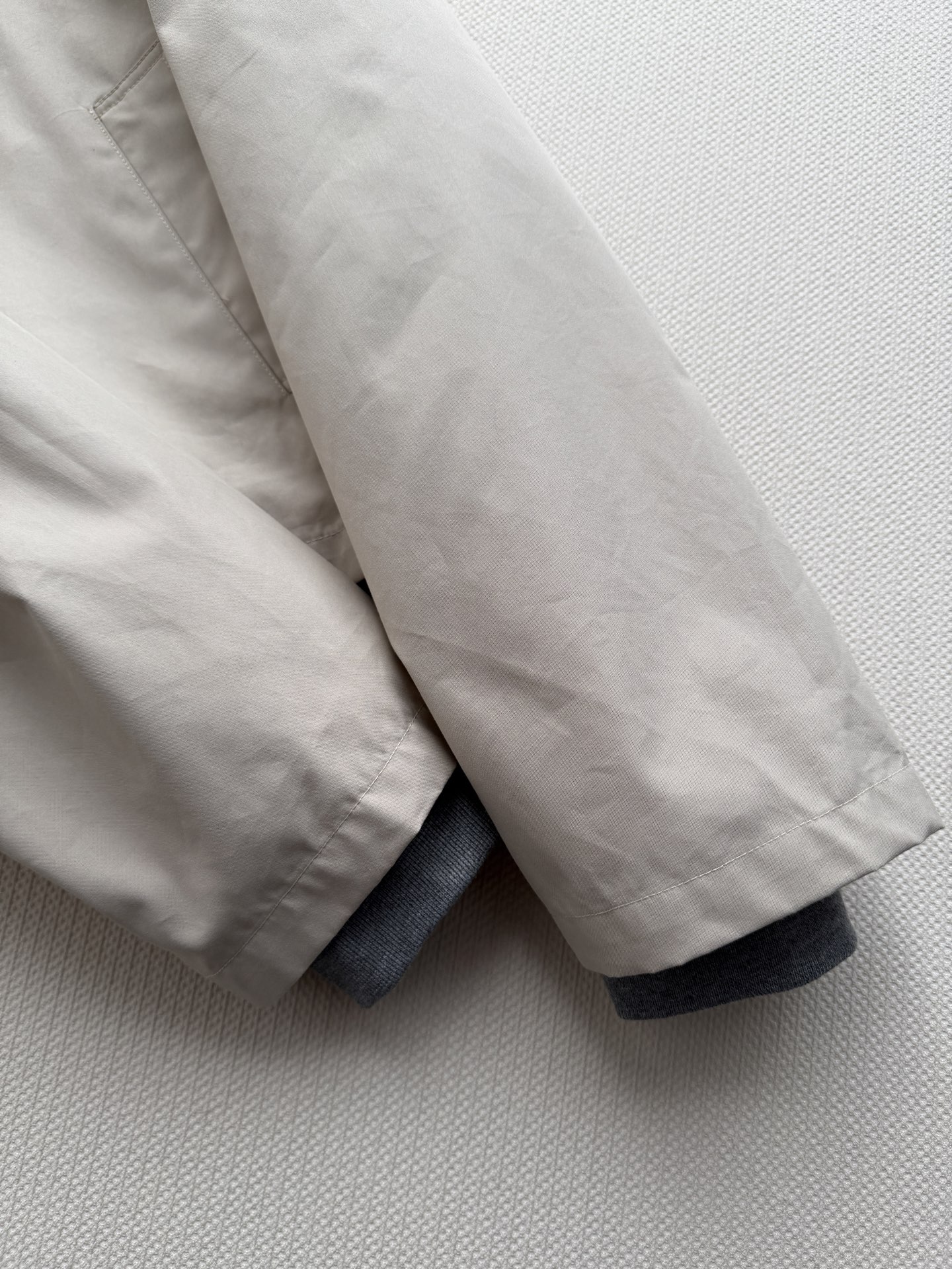 miumi*🆕米白色（接近奶白/杏仁白）棉质面料，有一定挺度但不是硬挺的那种。连帽设计配白色抽绳，前襟是单排扣+拉链的双