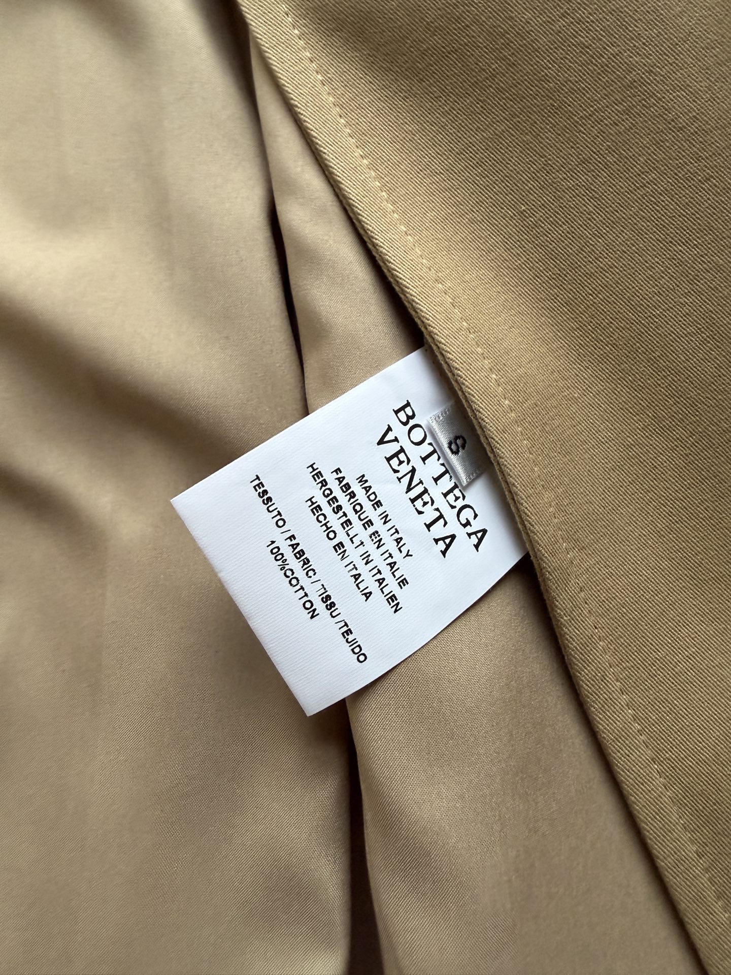 Bottega Veneta 26秋冬系列的卡其色编织皮领长款风衣​​。 经典卡其色棉质面料，质地挺括有结构感。领子内衬