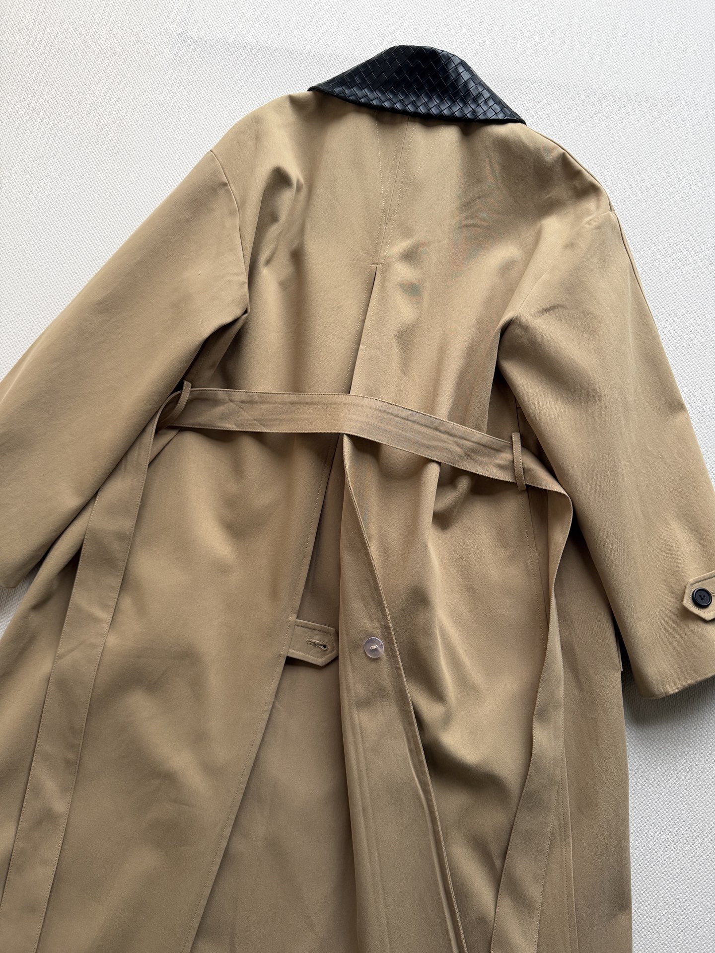Bottega Veneta 26秋冬系列的卡其色编织皮领长款风衣​​。 经典卡其色棉质面料，质地挺括有结构感。领子内衬