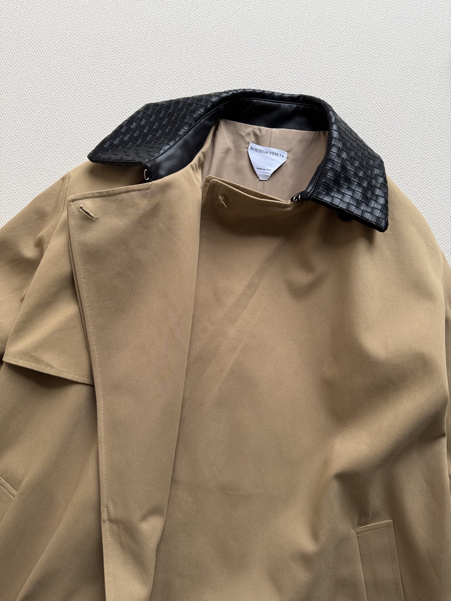 Bottega Veneta 26秋冬系列的卡其色编织皮领长款风衣​​。 经典卡其色棉质面料，质地挺括有结构感。领子内衬