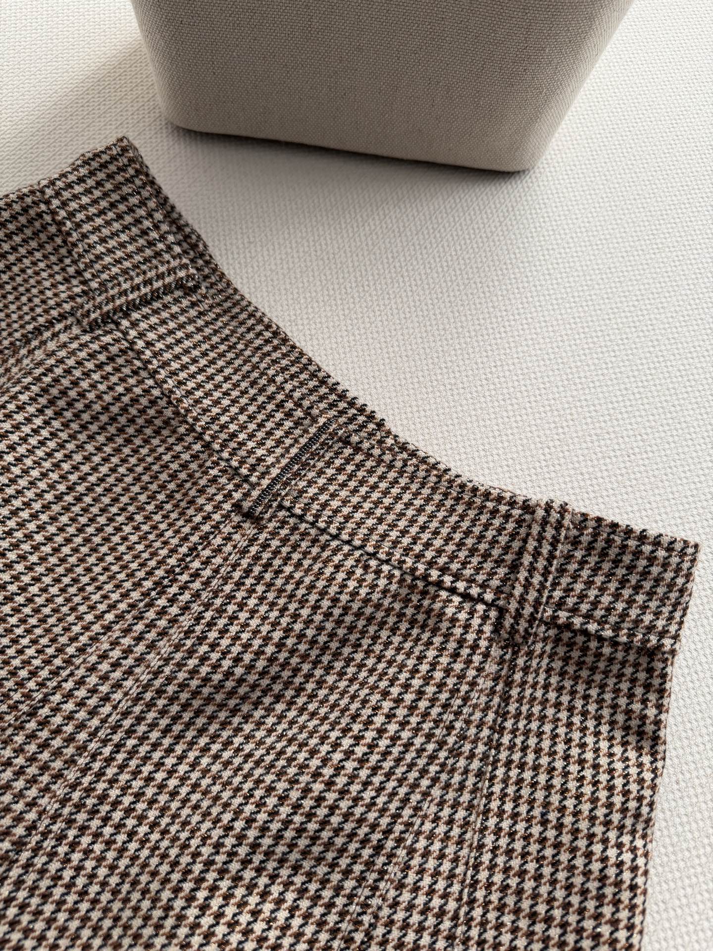 Brunello Cucinelli 🆕系列的珍贵材料重新诠释了这款初剪羊毛闪烁千鸟格半裙，经典鱼尾的熠熠生辉衬托下，营