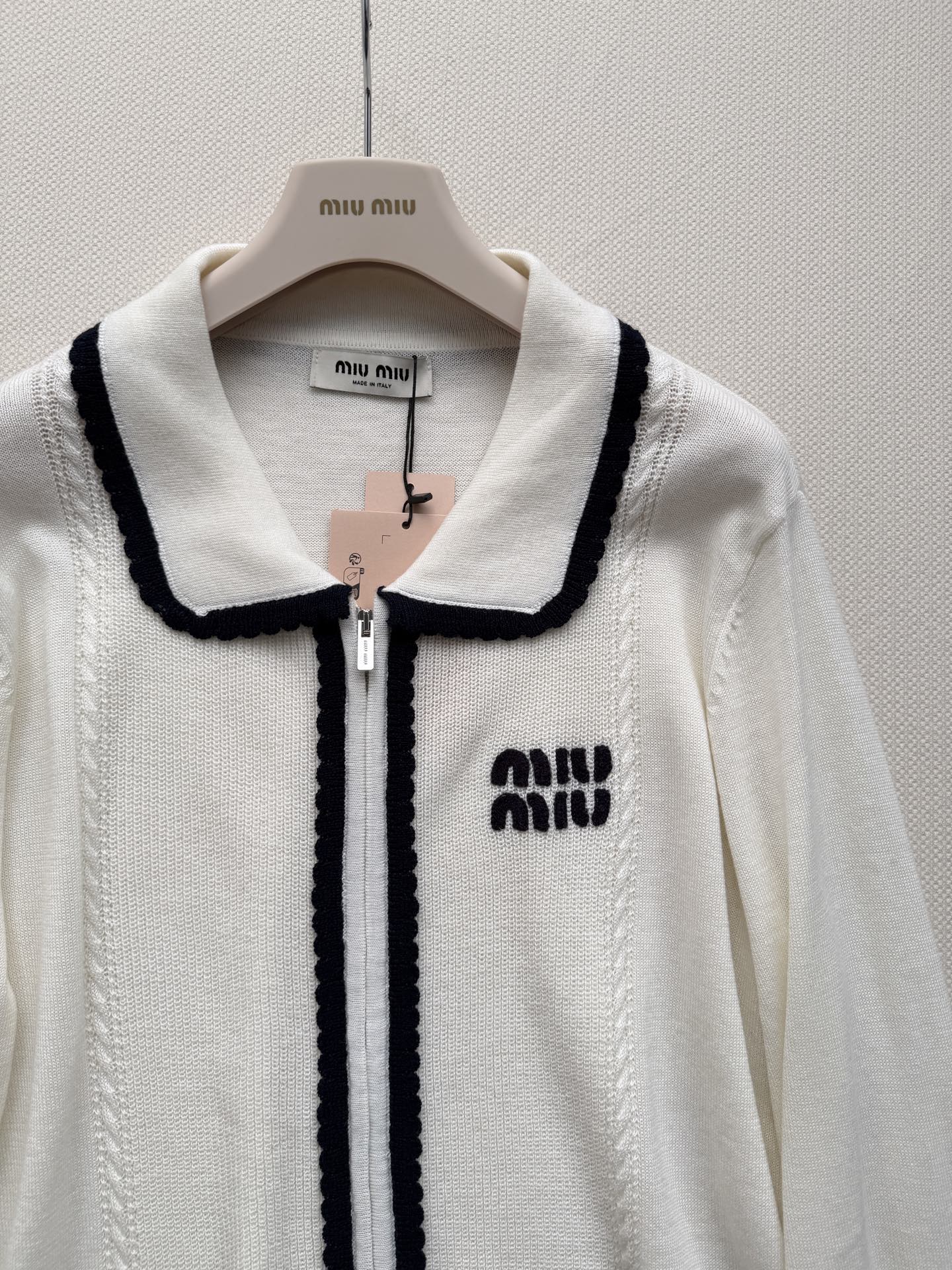 miumi*🆕质地紧密有弹性。翻领设计，领口、门襟和袖口都有白色的粗线滚边装饰，形成强烈的撞色效果。前襟拉链开合。左胸有