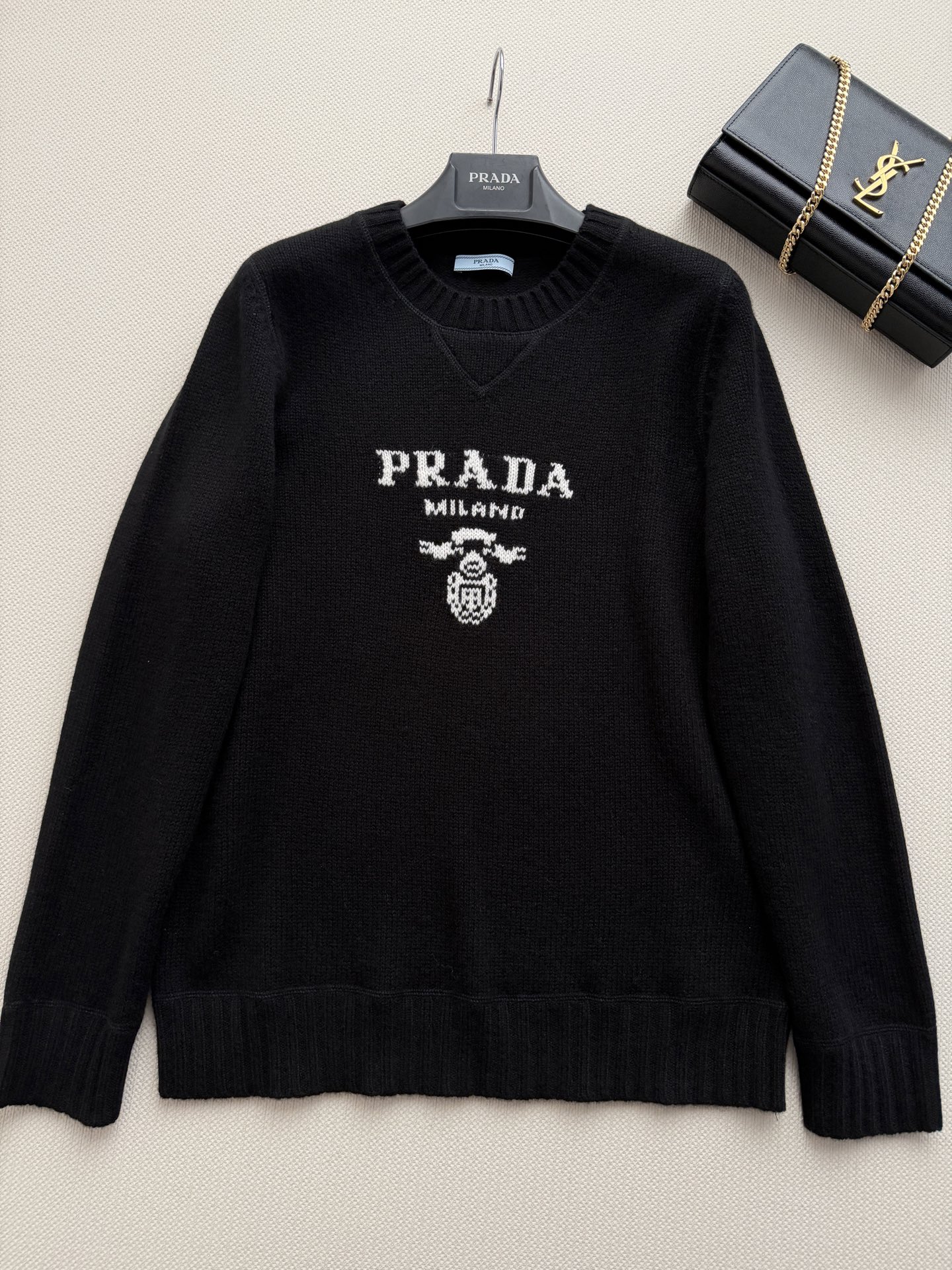 Prad*🆕细针编织，羊毛➕羊绒，质地细腻有微微的绒感。圆领设计，长袖，略宽松的廓形。胸口有 Prad*标志性的三角形徽