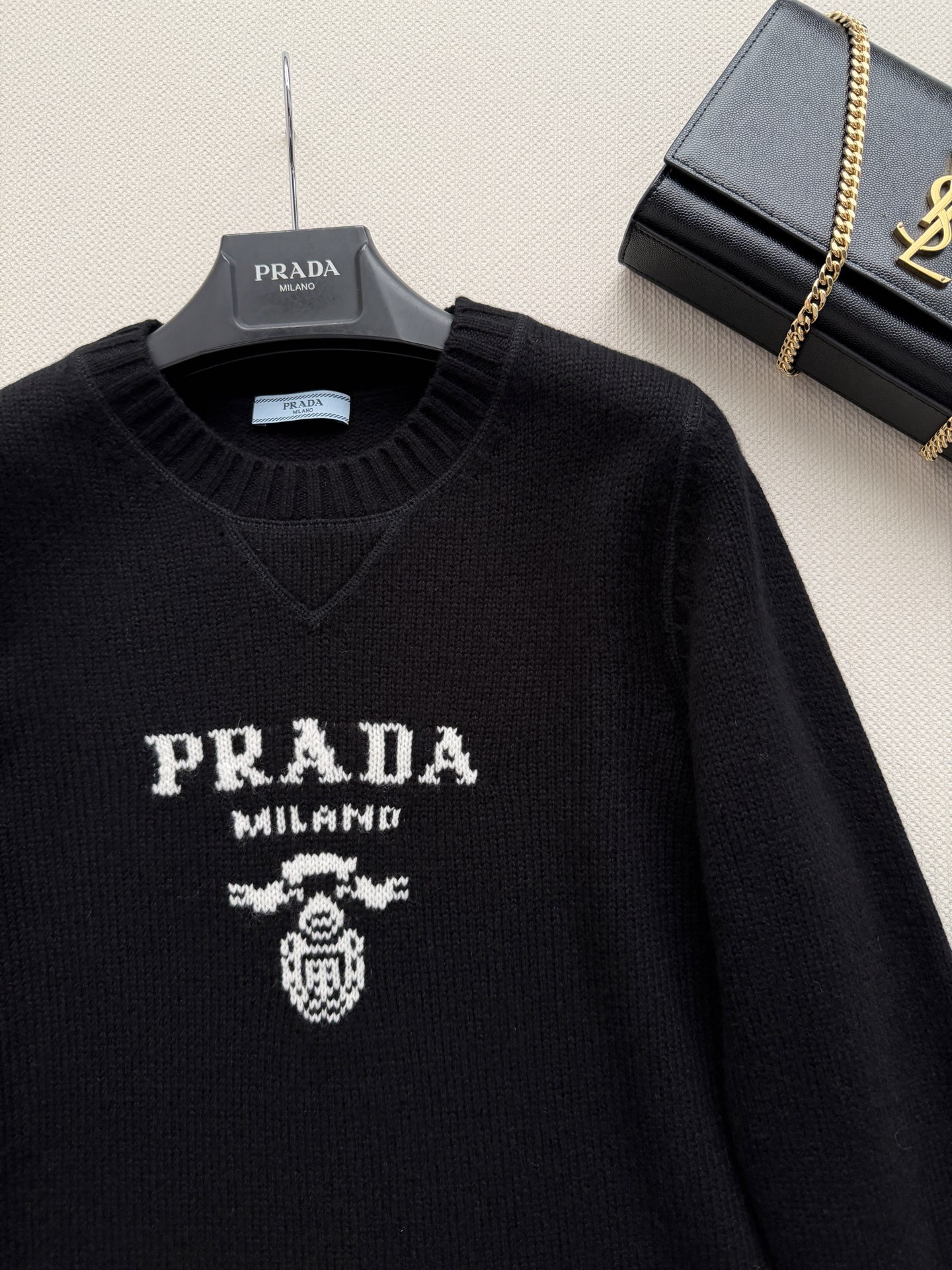 Prad*🆕细针编织，羊毛➕羊绒，质地细腻有微微的绒感。圆领设计，长袖，略宽松的廓形。胸口有 Prad*标志性的三角形徽