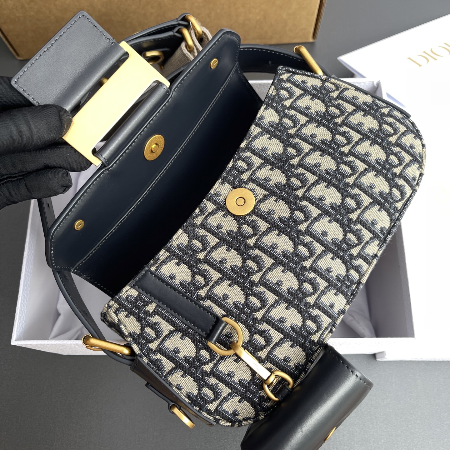 p890。【顶级高端～进口材料】Streetchic小号手袋

这款手袋采用蓝色Oblique印花面料和同色调光滑牛皮革精心制作，搭配磁性翻盖，饰以镌刻磁标志的复古金色饰面金属饰牌提升格调。带有一个同色调牛皮革可拆卸小袋，可收纳无线耳机，亦可挂在各D形饰环上。可调节，可拆卸肩带，可肩背或斜挎。
编号：M3913蓝D/刺绣
规格：w24×h12.5×d5cm
