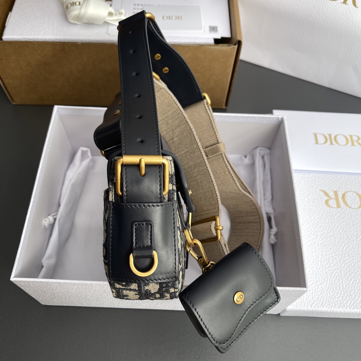 p890。【顶级高端～进口材料】Streetchic小号手袋

这款手袋采用蓝色Oblique印花面料和同色调光滑牛皮革精心制作，搭配磁性翻盖，饰以镌刻磁标志的复古金色饰面金属饰牌提升格调。带有一个同色调牛皮革可拆卸小袋，可收纳无线耳机，亦可挂在各D形饰环上。可调节，可拆卸肩带，可肩背或斜挎。
编号：M3913蓝D/刺绣
规格：w24×h12.5×d5cm
