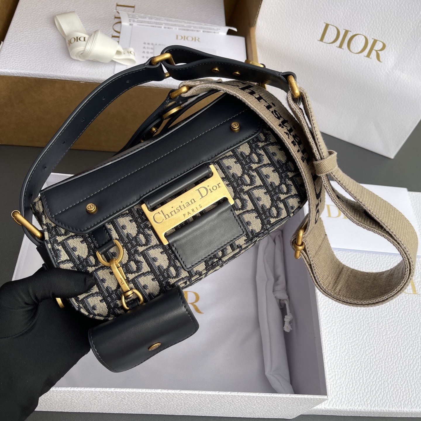 p890。【顶级高端～进口材料】Streetchic小号手袋

这款手袋采用蓝色Oblique印花面料和同色调光滑牛皮革精心制作，搭配磁性翻盖，饰以镌刻磁标志的复古金色饰面金属饰牌提升格调。带有一个同色调牛皮革可拆卸小袋，可收纳无线耳机，亦可挂在各D形饰环上。可调节，可拆卸肩带，可肩背或斜挎。
编号：M3913蓝D/刺绣
规格：w24×h12.5×d5cm
