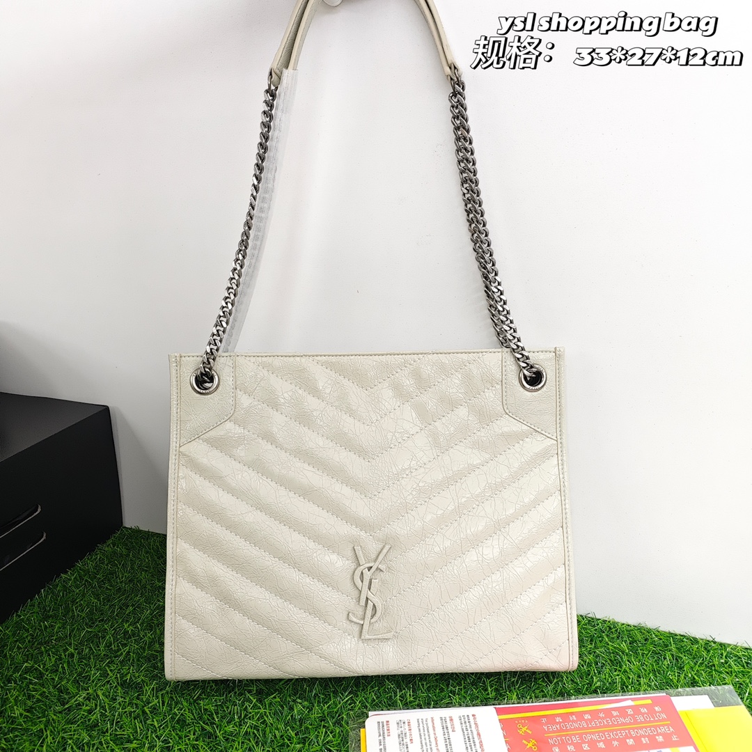 圣罗兰Niki shopping bag💰300 延续niki风格采用抓皱油蜡牛皮及logo使用真皮包裹设计,包袋中间有磁吸扣,保障了包包使用的安全性;内里有一拉链隔层及敞口插槽设计可放手机及零钱卡片,方便拿取,包包自重非常轻,容量又足够大,实用性爆表。 规格:33*27*12cm