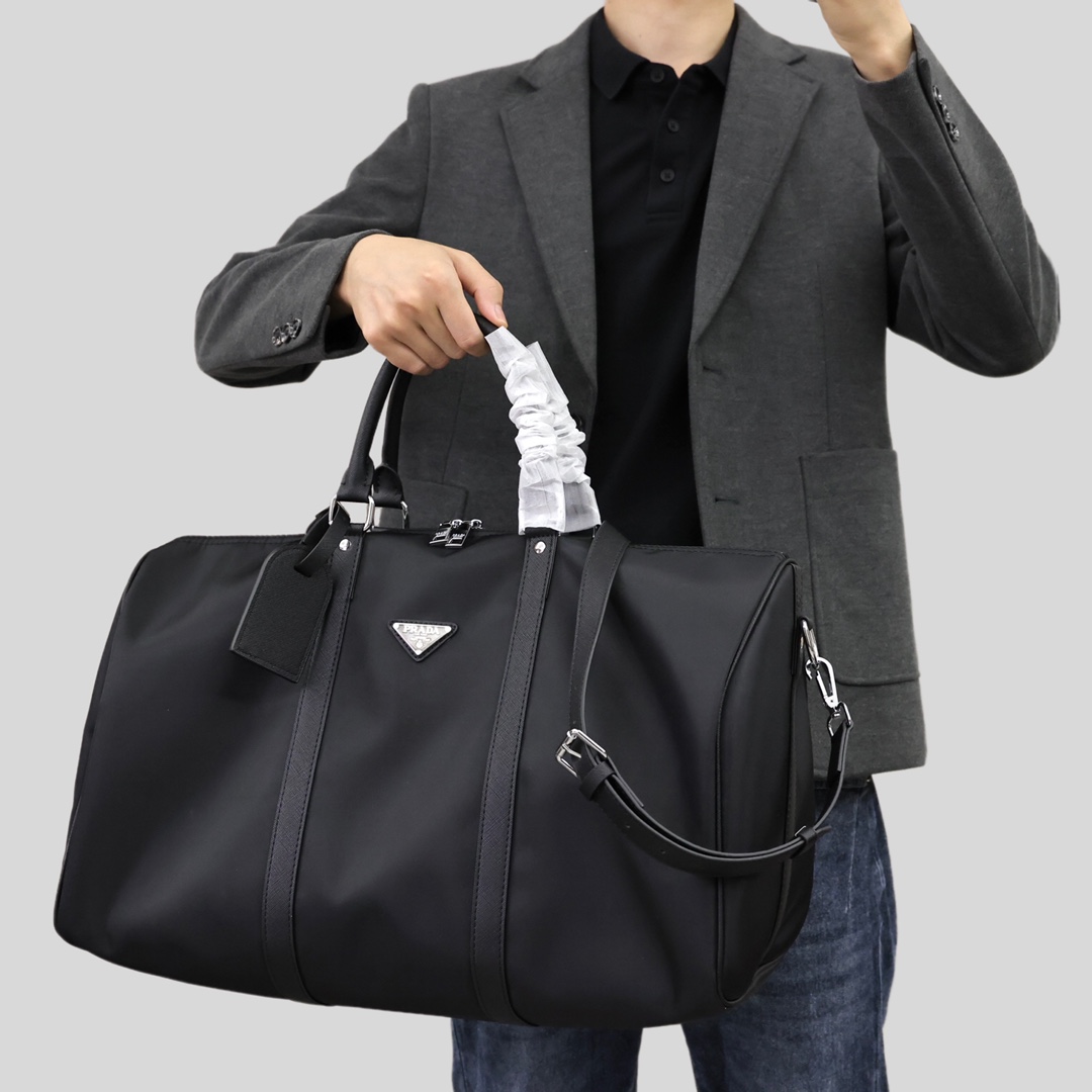 PRADA普拉达旅行袋💰280 采用进口降落伞布料,充满现代感的设计,永不过时,包身饰有标志性的三角形金属徽标,轻便又实用,旅游必备款。 规格:50*32*24cm