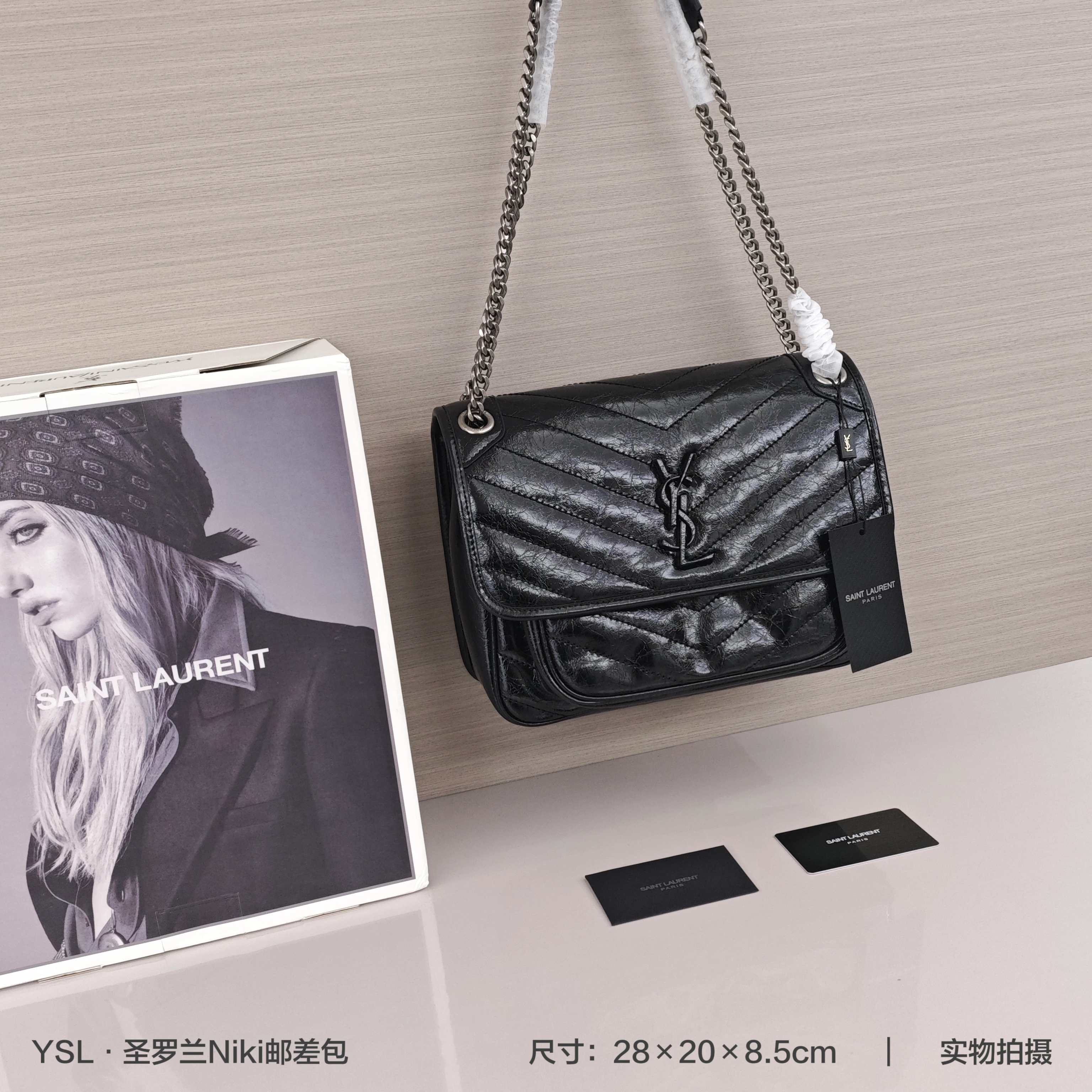 圣罗兰Niki邮差包💰340 柔软复古牛皮手袋,饰以V形明缝线和粒面皮革,空间充裕,设有两个隔层,背面设有一个大号贴袋,搭配滑动式链条肩带,可肩背或斜挎,拉丝钯金配件/磁性按扣开合/两个内部口袋。 规格:28×20×8.5cm