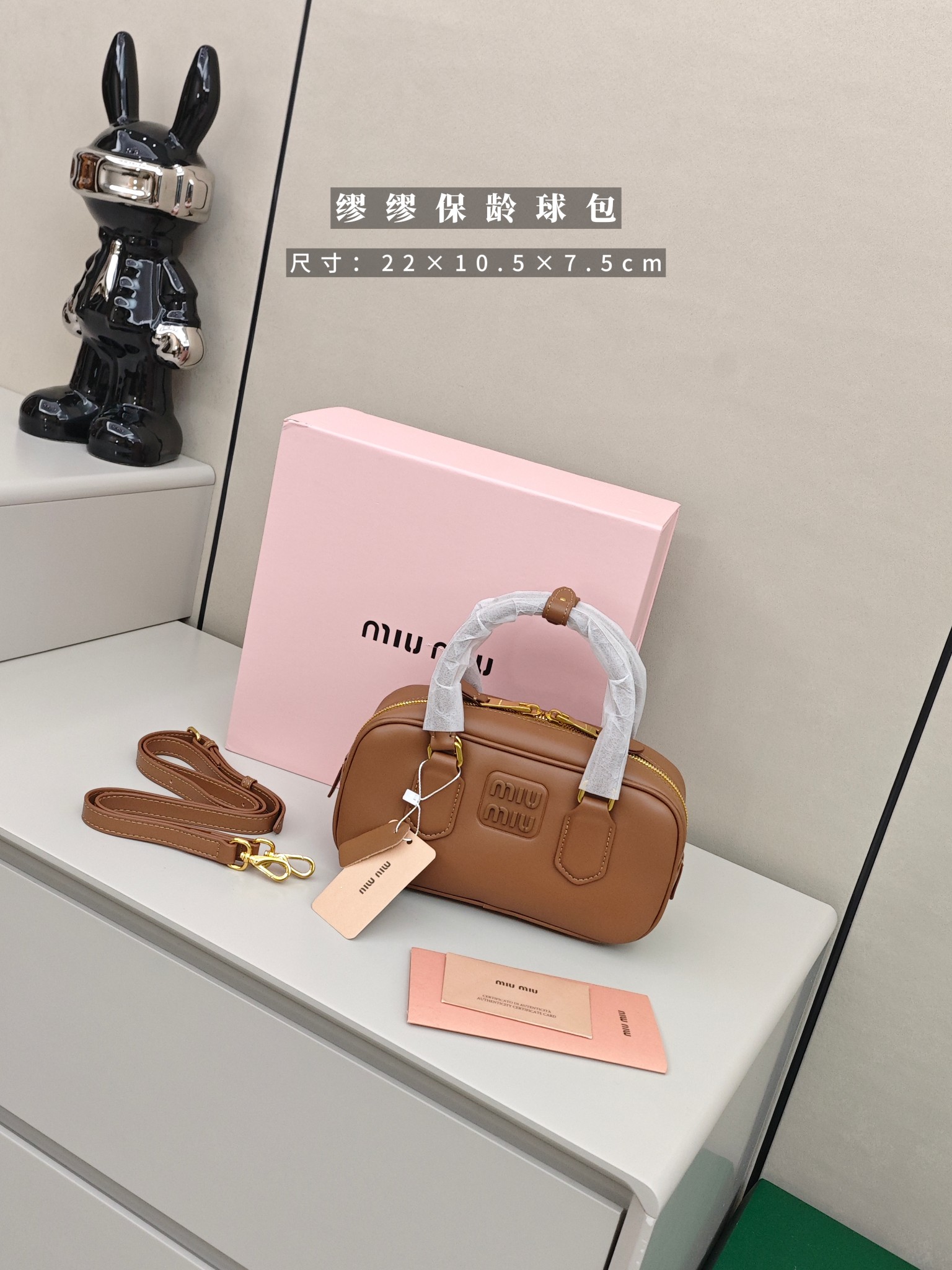 缪缪保龄球包 尺寸：22×10.5×7.5cm简介：细腻光滑的皮革材质，带着恰到好处的哑光质感，焦糖色调