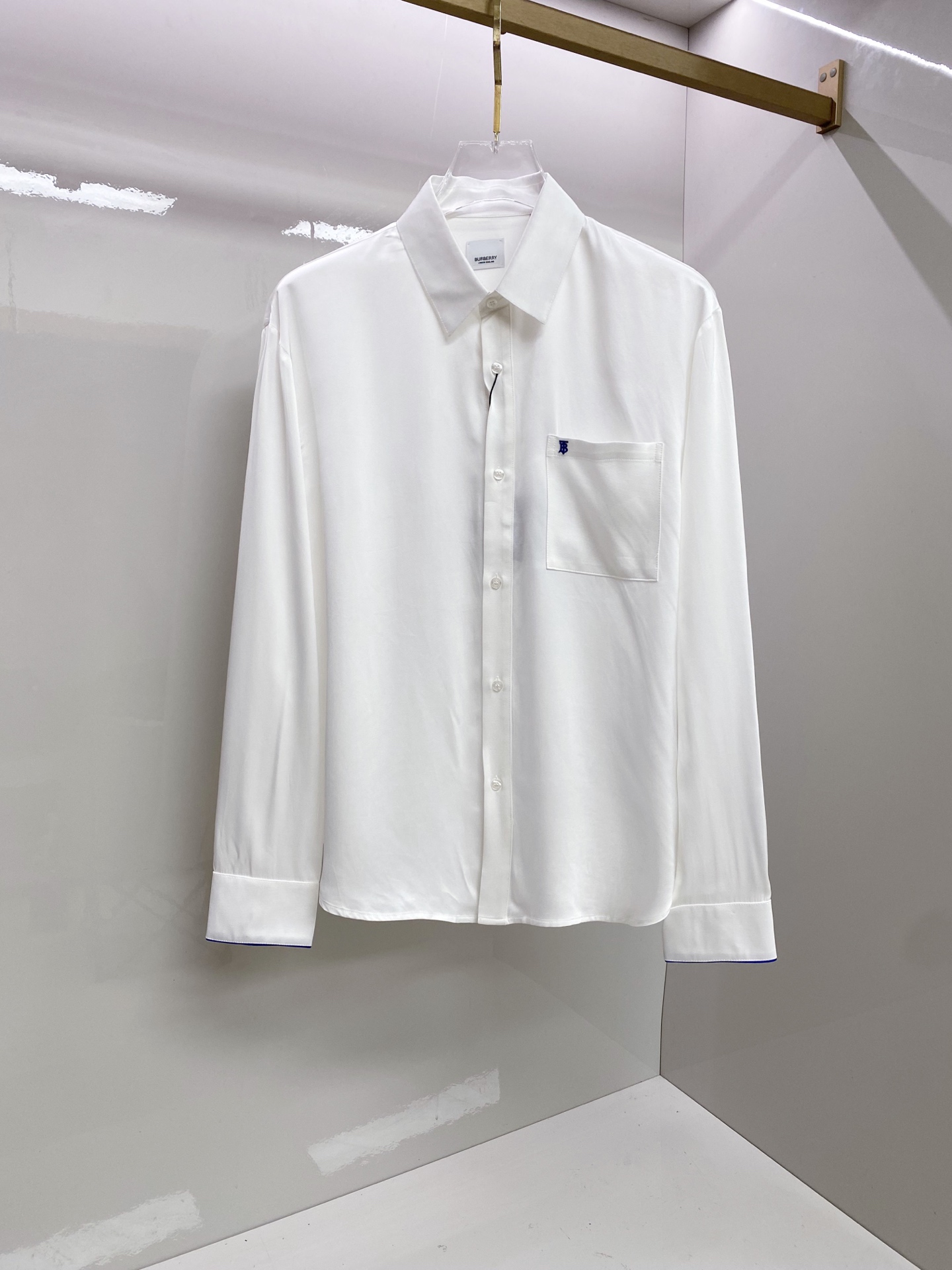 NO:835095,Burberry Burberry  2026ss spring and summer classic embroidered casual shirt, available in black/white, interprets British relaxed aesthetics with minimalist tailoring and iconic details. It is made of high-draping satin fabric, with a soft matte texture, silky and skin-friendly touch, and a draped and stylish upper body; the body is made of  The neat straight silhouette, with the equestrian knight logo embroidery on the chest and contrasting blue edge details on the cuffs, is low-key and injects brand recognition. The pleated design on the back optimizes the fit, whether worn alone, layered with a suit or paired with casual pants, it can easily create an effortless high-end look.  Size 48-56,,burberry,burberry,shirts,business suit,19860909Burberry 巴宝莉 2026ss春夏经典刺绣休闲衬衫,黑/白双色可选,以极简剪裁与标志性细节诠释英伦松弛美学.甄选高垂坠缎面面料打造,自带柔和哑光质感,触感丝滑亲肤,上身垂坠有型；衣身采用利落直筒版型,搭配胸口马术骑士徽标刺绣与袖口撞色蓝边细节,低调注入品牌辨识度.后背收褶设计优化版型,无论是单穿、叠穿西装还是搭配休闲裤,都能轻松塑造不费力的高阶质感穿搭. 码数48-56,,burberry,burberry,shirts,business suit,,Men's clothing