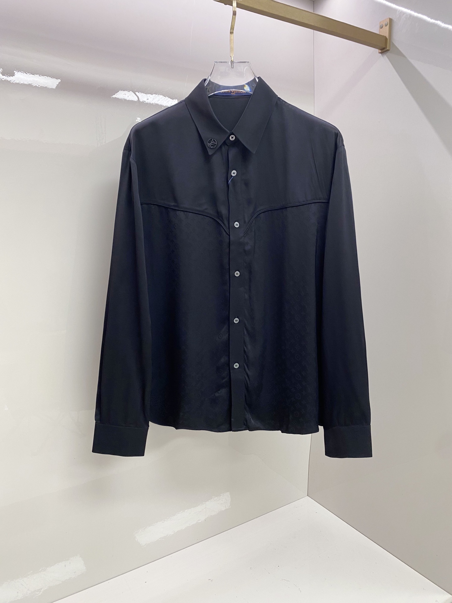NO:835109,LV  The 2026ss spring and summer western style satin black shirt interprets the dark high-end relaxed aesthetics with neat tailoring and details. It is made of high-draping satin fabric, which has a soft light texture, feels silky and skin-friendly, and has a draped and stylish upper body; the body adopts the iconic pattern of western shirts  The curved bust line divides it, and it is matched with metal logo details on the collar, which injects brand recognition in a low-key way. The neat straight silhouette is suitable for a variety of body shapes. Whether it is worn alone to create a cool commuting style, or layered with a suit to create a business elite look, it can easily create an effortless high-quality outfit.  Size 48-56,,louis vuitton,shirts,business suit,19860909LV 2026ss春夏西部风缎面黑衬衫,以利落剪裁与细节巧思诠释暗黑系高阶松弛美学.甄选高垂坠缎面面料打造,自带柔光质感,触感丝滑亲肤,上身垂坠有型；衣身采用西部衬衫标志性的弧形胸线分割,搭配领口金属徽标细节,低调注入品牌辨识度.利落直筒版型适配多元身形,无论是单穿打造酷感通勤风,还是叠穿西装演绎商务精英感,都能轻松塑造不费力的高级质感穿搭. 码数48-56,,louis vuitton,shirts,business suit,,Men's clothing