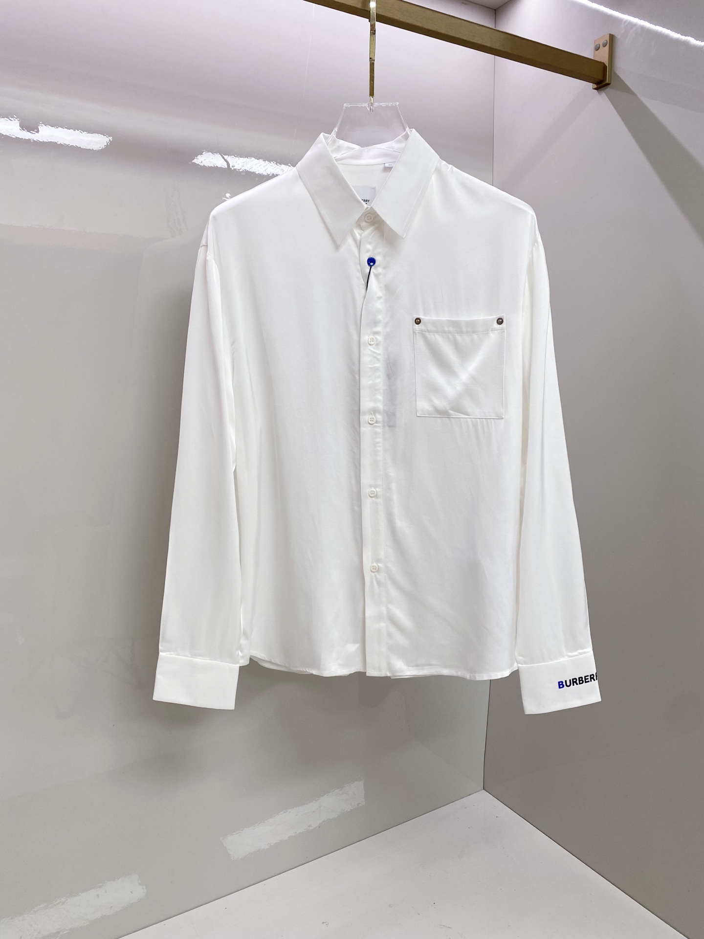 NO:835134,Burberry Burberry  2026ss spring and summer satin casual shirt, using minimalist tailoring and brand details to interpret a high-end sense of relaxation. It is made of high-draping satin fabric, with a soft luster, silky touch and skin-friendly, and a soft light filter on the upper body; the body is made of neat straight legs  The style is matched with contrasting blue buttons and rivet pocket details to break the dullness. The exclusive brand logo on the cuffs and the pleated design on the back strictly echo each other. Whether worn alone, layered with a suit or paired with casual pants, it can easily create an effortless high-end look.  Size 48-56,,burberry,burberry,shirts,business suit,19860909Burberry 巴宝莉 2026ss春夏缎面休闲衬衫,以极简剪裁与品牌细节诠释高级松弛感.甄选高垂坠缎面面料打造,自带柔和光泽,触感丝滑亲肤,上身自带柔光滤镜；衣身采用利落直筒版型,搭配撞色蓝扣与铆钉口袋细节,打破沉闷.袖口专属品牌标识与后背收褶设计严谨呼应,无论是单穿、叠穿西装还是搭配休闲裤,都能轻松塑造不费力的高阶质感穿搭. 码数48-56,,burberry,burberry,shirts,business suit,,Men's clothing