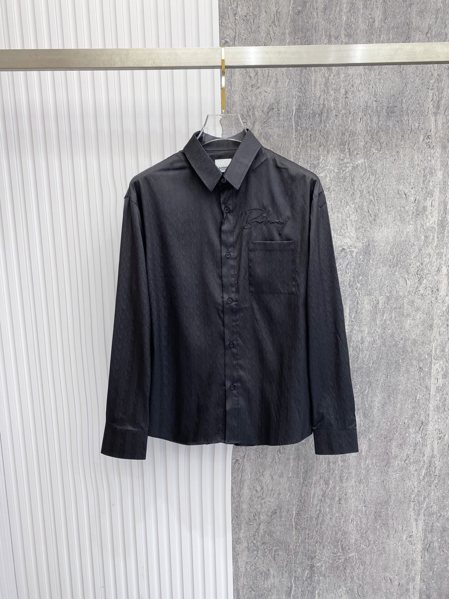 NO:842768,Burberry 2026ss spring and summer dark pattern embroidered shirt  The black/white two-color high-performance new style uses dark jacquard technology and handwritten embroidery to perfectly interpret the British high-end relaxed feeling. High-draping mercerized fabrics are selected, with delicate luster and smooth skin-friendly touch. The upper body is draped and stylish, anti-wrinkle and easy to care for. The body adopts a neat straight shape, with a chest  The handwriting embroidery and dark jacquard details strictly echo each other, injecting brand recognition in a low-key way; the gathered back design optimizes the fit and allows for freedom of movement. Whether worn alone to create a refreshing commuting style, or layered with a suit to create a business elite feel, it can easily create an effortless high-end texture.  Size 48-56,,burberry,burberry,shirts,business suit,19860909Burberry 巴宝莉 2026ss春夏暗纹刺绣衬衫 黑/白双色高能上新,以暗纹提花工艺融合手写体刺绣,完美演绎英伦高阶松弛感.甄选高垂坠丝光面料,自带细腻光泽与顺滑亲肤触感,上身垂坠有型,抗皱易打理.衣身采用利落直筒版型,胸口手写体刺绣与暗纹提花细节严谨呼应,低调注入品牌辨识度；后背收褶设计优化版型,活动自如.无论是单穿打造清爽通勤风,还是叠穿西装演绎商务精英感,都能轻松塑造不费力的高阶质感. 码数48-56,,burberry,burberry,shirts,business suit,,Men's clothing