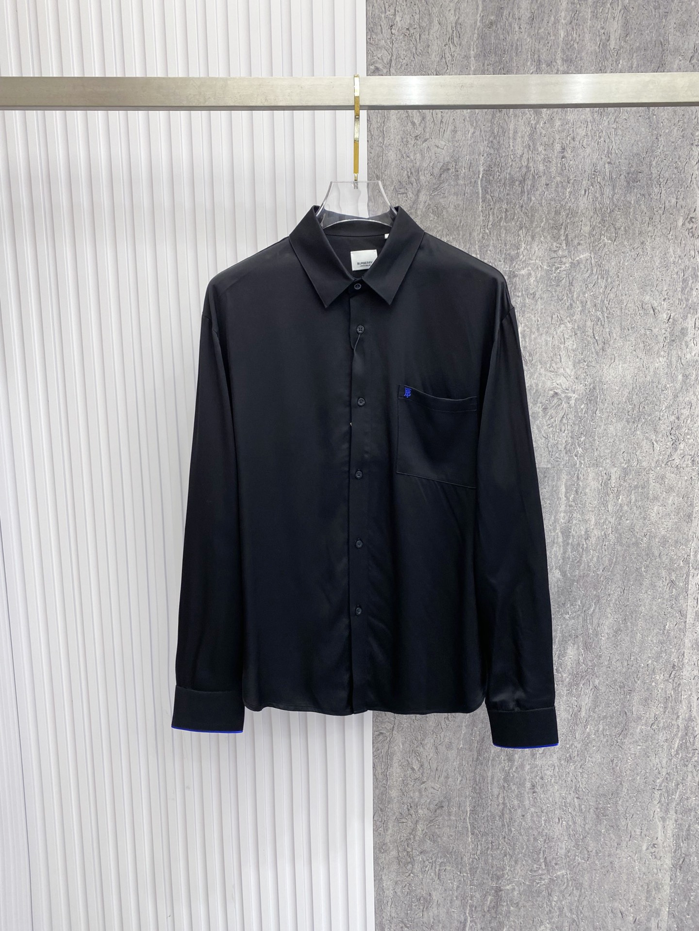 NO:842762,Burberry Burberry  2026ss spring and summer classic embroidered casual shirt, available in black/white, interprets British relaxed aesthetics with minimalist tailoring and iconic details. It is made of high-draping satin fabric, with a soft matte texture, silky and skin-friendly touch, and a draped and stylish upper body; the body is made of  The neat straight silhouette, with the equestrian knight logo embroidery on the chest and contrasting blue edge details on the cuffs, is low-key and injects brand recognition. The pleated design on the back optimizes the fit, whether worn alone, layered with a suit or paired with casual pants, it can easily create an effortless high-end look.  Size 48-56,,burberry,burberry,shirts,business suit,19860909Burberry 巴宝莉 2026ss春夏经典刺绣休闲衬衫,黑/白双色可选,以极简剪裁与标志性细节诠释英伦松弛美学.甄选高垂坠缎面面料打造,自带柔和哑光质感,触感丝滑亲肤,上身垂坠有型；衣身采用利落直筒版型,搭配胸口马术骑士徽标刺绣与袖口撞色蓝边细节,低调注入品牌辨识度.后背收褶设计优化版型,无论是单穿、叠穿西装还是搭配休闲裤,都能轻松塑造不费力的高阶质感穿搭. 码数48-56,,burberry,burberry,shirts,business suit,,Men's clothing