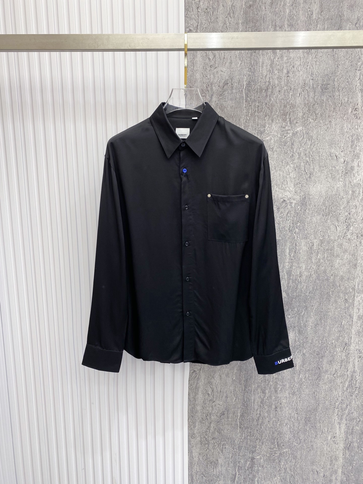 NO:842756,Burberry Burberry  2026ss spring and summer satin casual shirt, using minimalist tailoring and brand details to interpret a high-end sense of relaxation. It is made of high-draping satin fabric, with a soft luster, silky touch and skin-friendly, and a soft light filter on the upper body; the body is made of neat straight legs  The style is matched with contrasting blue buttons and rivet pocket details to break the dullness. The exclusive brand logo on the cuffs and the pleated design on the back strictly echo each other. Whether worn alone, layered with a suit or paired with casual pants, it can easily create an effortless high-end look.  Size 48-56,,burberry,burberry,shirts,business suit,19860909Burberry 巴宝莉 2026ss春夏缎面休闲衬衫,以极简剪裁与品牌细节诠释高级松弛感.甄选高垂坠缎面面料打造,自带柔和光泽,触感丝滑亲肤,上身自带柔光滤镜；衣身采用利落直筒版型,搭配撞色蓝扣与铆钉口袋细节,打破沉闷.袖口专属品牌标识与后背收褶设计严谨呼应,无论是单穿、叠穿西装还是搭配休闲裤,都能轻松塑造不费力的高阶质感穿搭. 码数48-56,,burberry,burberry,shirts,business suit,,Men's clothing
