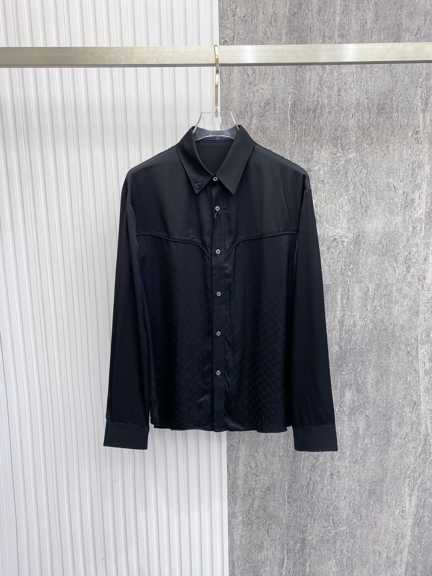 NO:842776,LV  The 2026ss spring and summer western style satin black shirt interprets the dark high-end relaxed aesthetics with neat tailoring and details. It is made of high-draping satin fabric, which has a soft light texture, feels silky and skin-friendly, and has a draped and stylish upper body; the body adopts the iconic pattern of western shirts  The curved bust line divides it, and it is matched with metal logo details on the collar, which injects brand recognition in a low-key way. The neat straight silhouette is suitable for a variety of body shapes. Whether it is worn alone to create a cool commuting style, or layered with a suit to create a business elite look, it can easily create an effortless high-quality outfit.  Size 48-56,,louis vuitton,shirts,business suit,19860909LV 2026ss春夏西部风缎面黑衬衫,以利落剪裁与细节巧思诠释暗黑系高阶松弛美学.甄选高垂坠缎面面料打造,自带柔光质感,触感丝滑亲肤,上身垂坠有型；衣身采用西部衬衫标志性的弧形胸线分割,搭配领口金属徽标细节,低调注入品牌辨识度.利落直筒版型适配多元身形,无论是单穿打造酷感通勤风,还是叠穿西装演绎商务精英感,都能轻松塑造不费力的高级质感穿搭. 码数48-56,,louis vuitton,shirts,business suit,,Men's clothing
