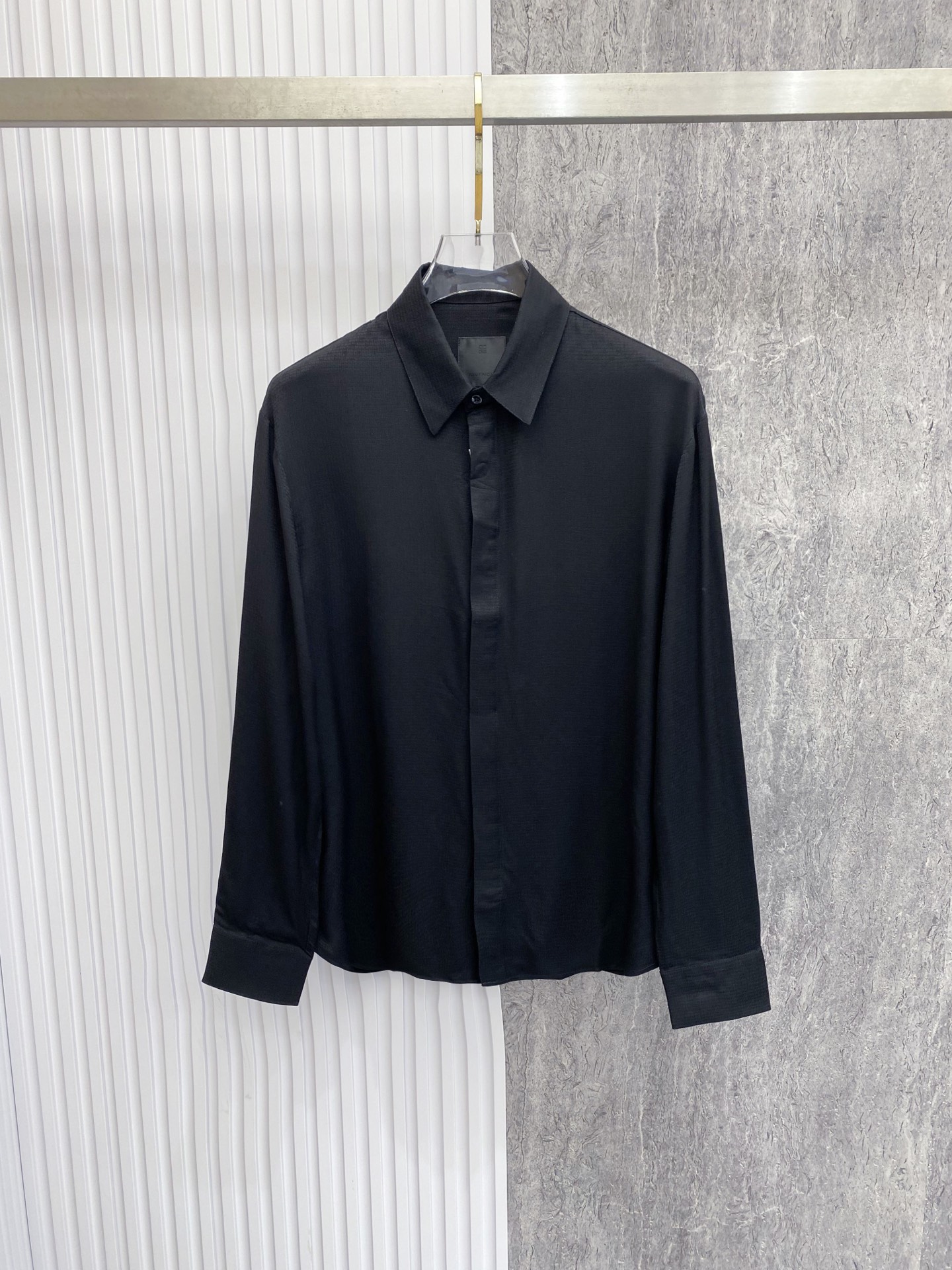 NO:842779,Givenchy 2026ss spring and summer dark pattern jacquard black shirt  It interprets high-end relaxed aesthetics with minimalist tailoring and delicate craftsmanship. It is made of high-draping matte satin fabric, which feels silky and skin-friendly, with a low-key soft light texture. The upper body is draped and stylish, and is anti-wrinkle and easy to care for. The body adopts a neat straight silhouette with full width.  The dark pattern jacquard is low-key to inject brand recognition, and paired with a hidden fly design, it is exquisite and neat. Whether worn alone to create a cool commuting style, or layered with a suit to create a business elite feel, it can easily create an effortless high-quality outfit.  Size 48-56,,givenchy,givenchy,shirts,business suit,19860909Givenchy 纪梵希 2026ss春夏暗纹提花黑衬衫 以极简剪裁与细腻工艺诠释高阶松弛美学,甄选高垂坠哑光缎面面料打造,触感丝滑亲肤,自带低调柔光质感,上身垂坠有型且抗皱易打理.衣身采用利落直筒版型,满幅暗纹提花低调注入品牌辨识度,搭配隐藏式门襟设计,尽显精致利落.无论是单穿打造酷感通勤风,还是叠穿西装演绎商务精英感,都能轻松塑造不费力的高级质感穿搭. 码数48-56,,givenchy,givenchy,shirts,business suit,,Men's clothing