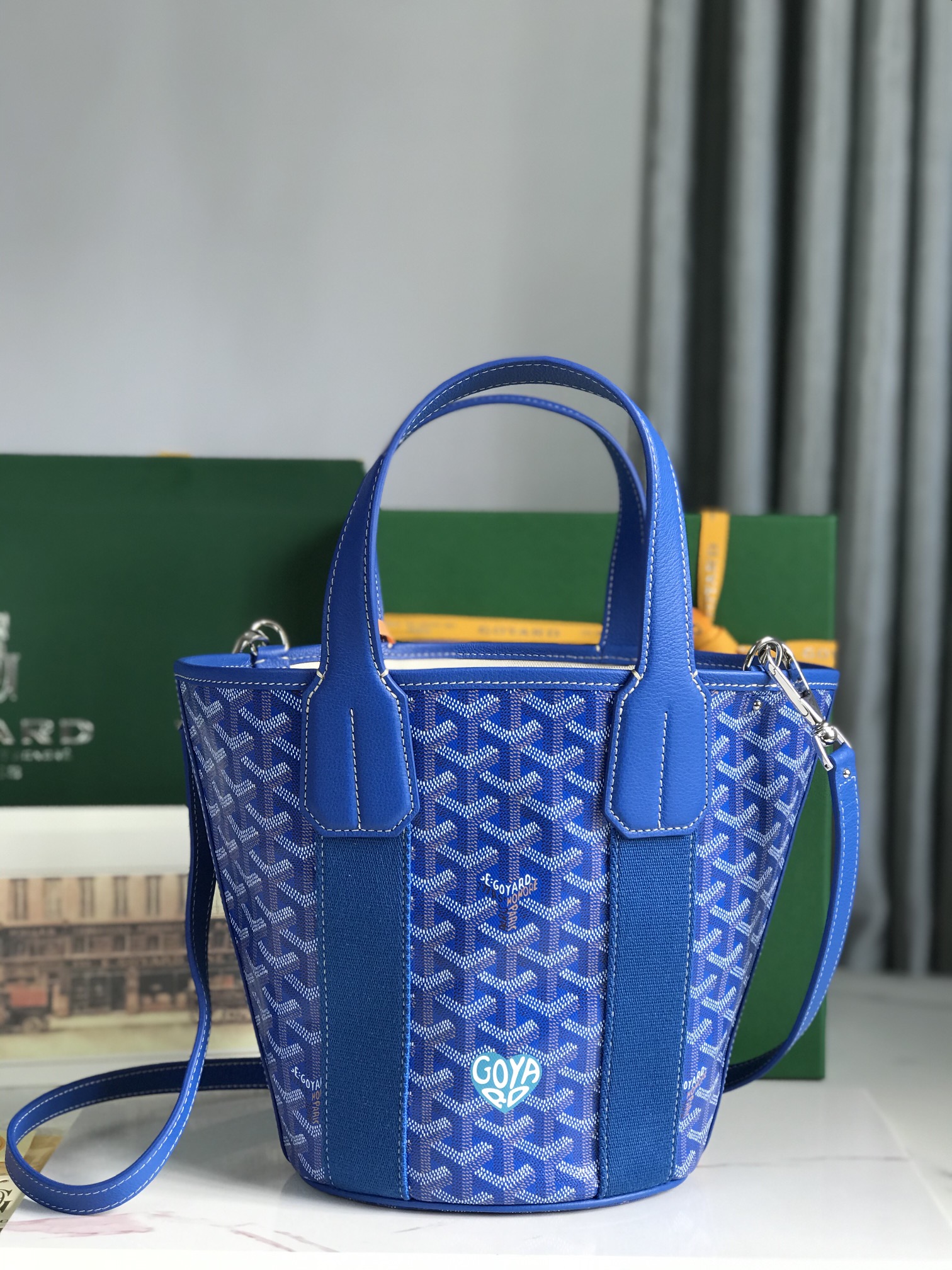The 💝BELHARRA mini bucket bag is the perfect companion for sunny vacations. Its signature bucket shape and wide opening easily hold daily essentials. Whether on the beach or city streets, this special edition bag can be carried by hand or worn on the shoulder. The removable calf leather strap adds versatility. Available in 11 classic colors with two heart designs: the small heart adds a playful, unique touch, while the woven heart offers a fresh, soft, and dynamic look. Size: 18*14 (base width) *24 cm (height). 🔎120230 image 1