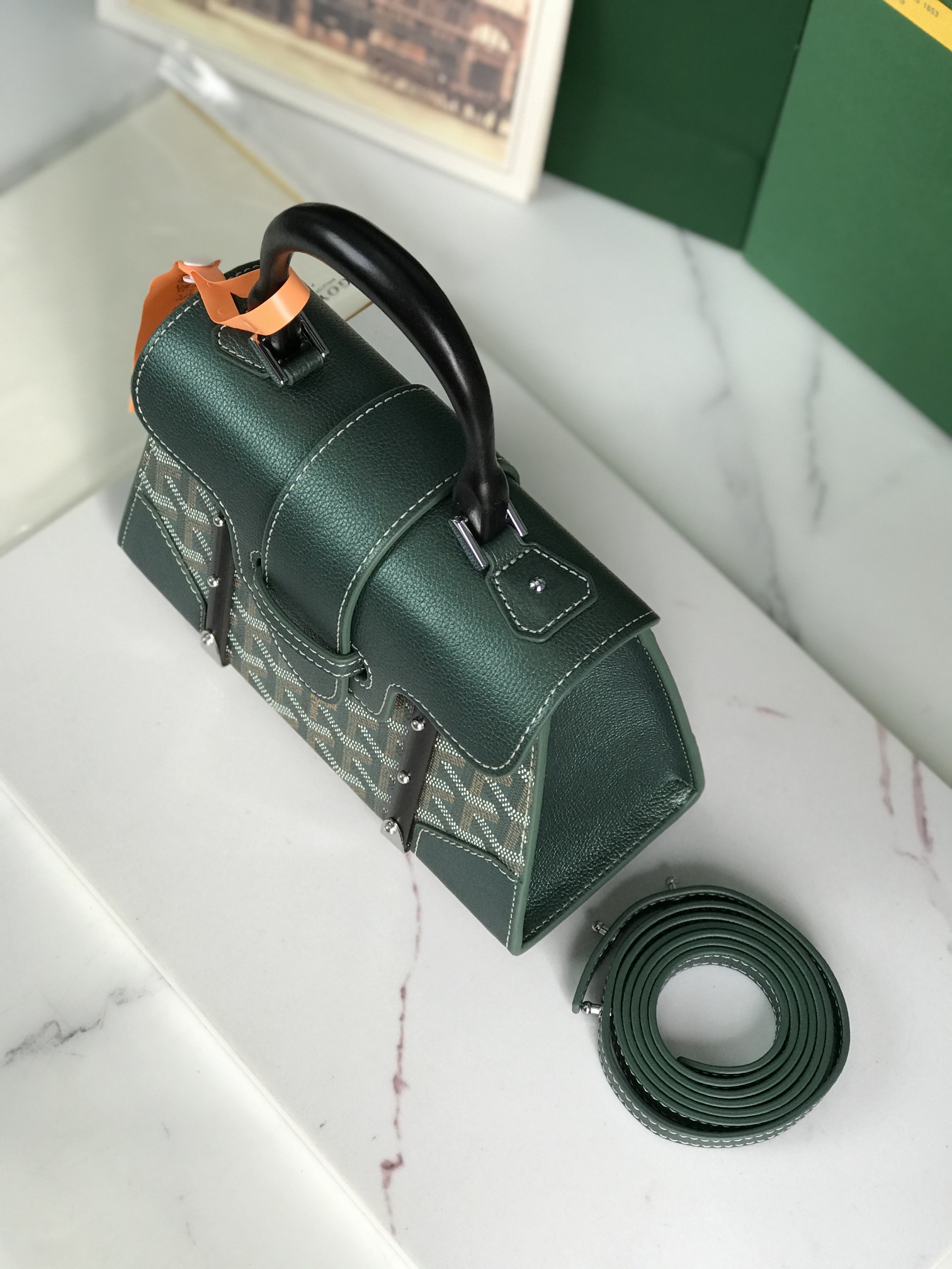 p750。💗配原版盒🎁
珠光绿上新！
Goyard Saïgon包于二十世纪三十年代问世，继推出柔软版Saïgon迷你包后，Goyard推陈出新，坚持对创意的不断追求与突破，塑造了全新结构化的Saïgon迷你包。它与初版Saïgon包的外型一样，拥有简约的几何线条与制箱工艺的细节，以小巧精致的外观唤起Goyard独一无二的优雅魅力及旅行精神。风格经典又符合当代人偏爱使用“小包”的潮流趋势，是匠心之作。可拆卸的皮革肩带能巧妙地转换成三种背法——手提、斜跨和肩背
尺寸size：21*14*8.5cm
🔎020192