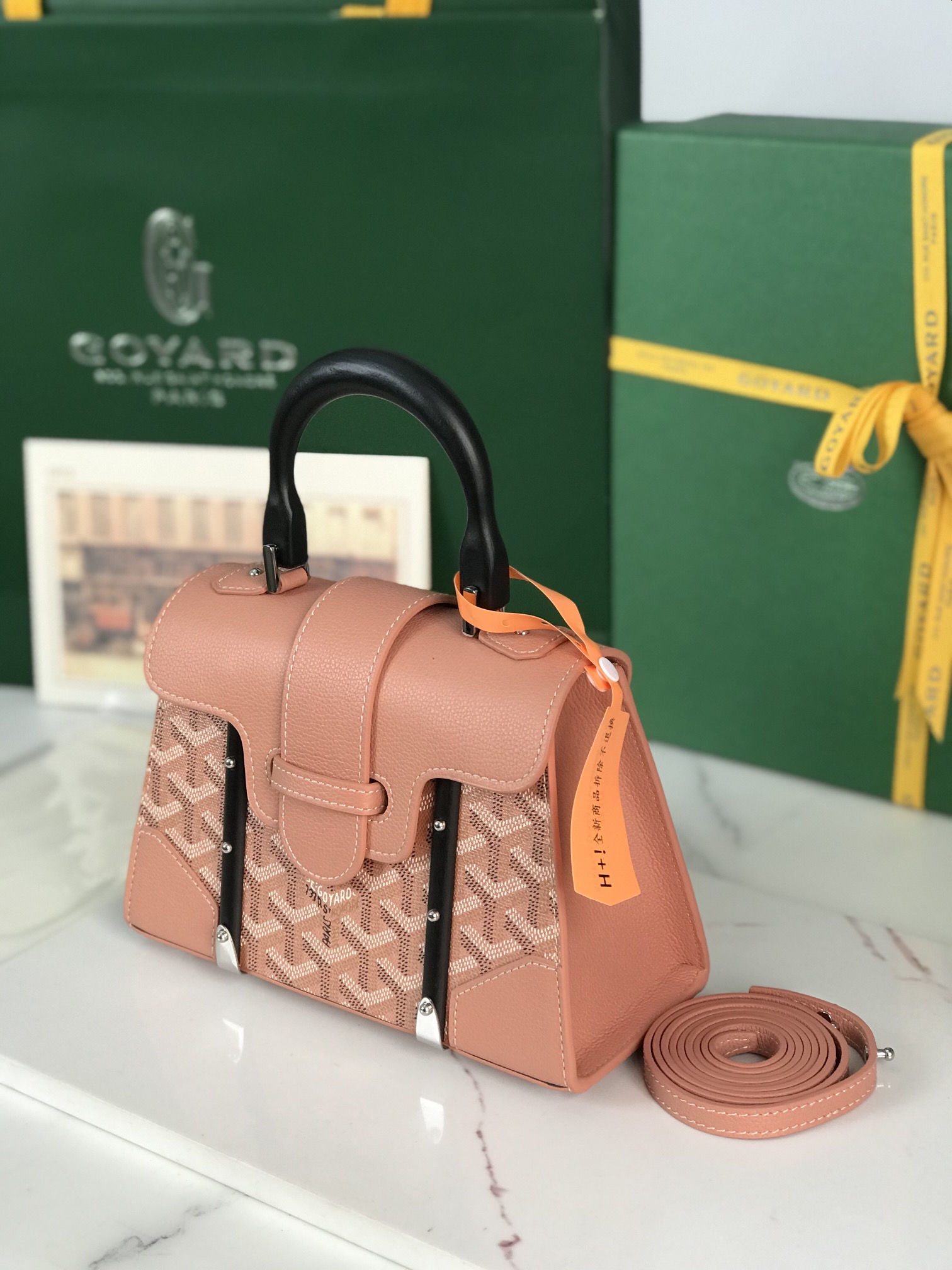 p750。💗配原版盒🎁
珠光粉上新！
Goyard Saïgon包于二十世纪三十年代问世，继推出柔软版Saïgon迷你包后，Goyard推陈出新，坚持对创意的不断追求与突破，塑造了全新结构化的Saïgon迷你包。它与初版Saïgon包的外型一样，拥有简约的几何线条与制箱工艺的细节，以小巧精致的外观唤起Goyard独一无二的优雅魅力及旅行精神。风格经典又符合当代人偏爱使用“小包”的潮流趋势，是匠心之作。可拆卸的皮革肩带能巧妙地转换成三种背法——手提、斜跨和肩背
尺寸size：21*14*8.5cm
🔎020192