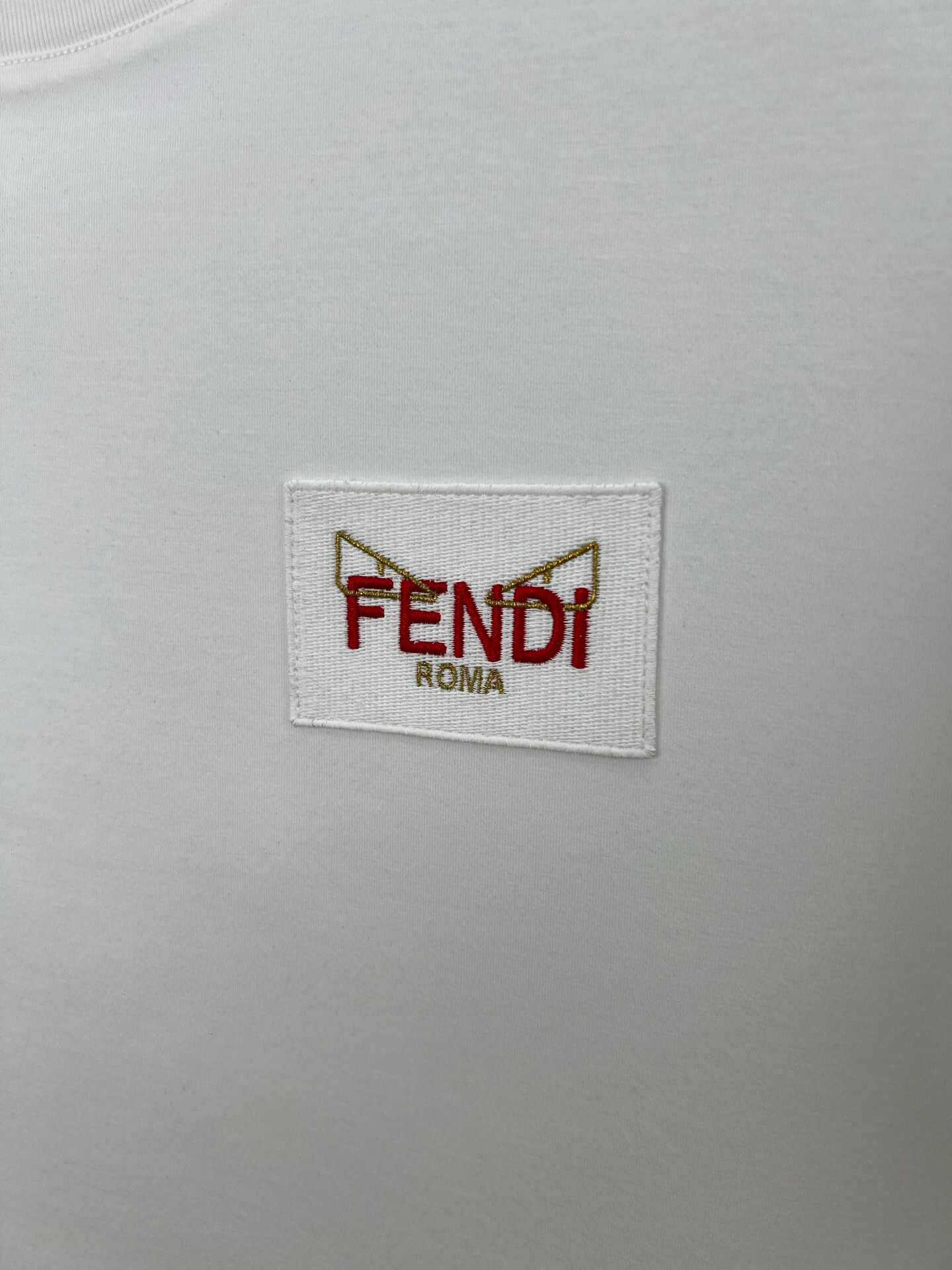 P85 FENDI 25春夏新品小怪兽刺绣徽章短袖T恤，正面胸前饰有FENDI Roma字样以及红色和金色FENDI Eyes刺绣徽章设计，下脚缝有FENDI贴条标识并附有颗F型五孔珍珠贝母纽扣，彰显品牌的独有设计。定制260纯棉面料；黑色 白色s—xxl