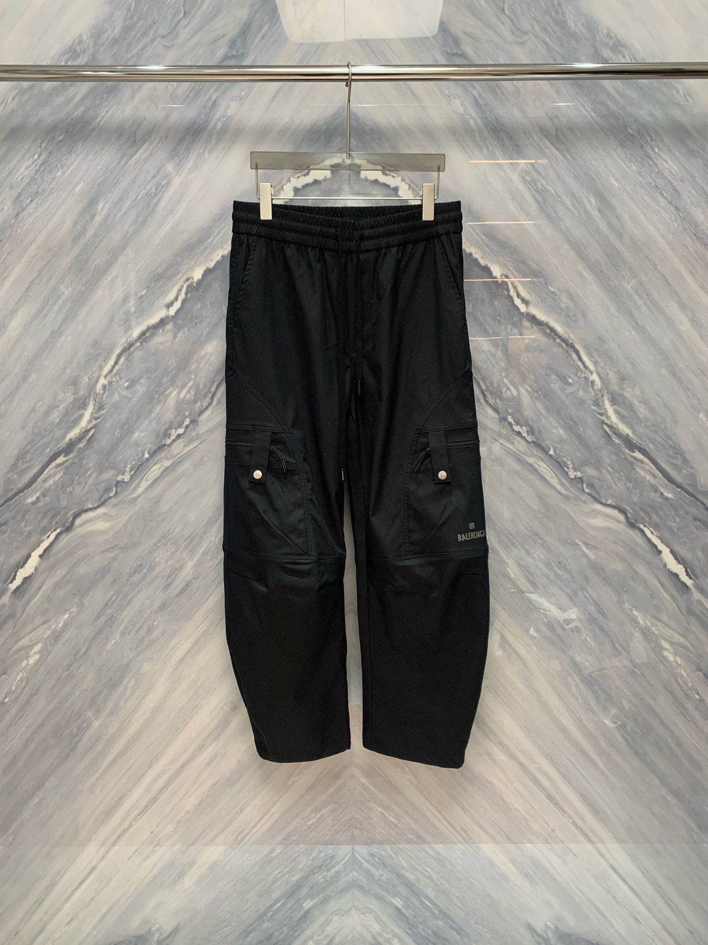 NO:141377,Paris Home 2025 spring and summer new three-dimensional tailoring loose straight pants classic black, multi-functional pockets, comfortable and versatile, showing a fashionable style, a perfect combination of fashion and practicality. This Paris Home Working Pants adopts a classic black design, with multiple functional pockets on both sides, each pocket is equipped with metal buckle, which is both practical and adds a tough feeling. The waist is designed with elastic bands and matched with drawstrings to ensure a comfortable fit. Selected high-quality cotton-blend fabric, soft and skin-friendly, and has good breathability, suitable for all seasons to wear. The fabric has been specially treated and has certain waterproof functions, which can be kept dry even on rainy days. The loose style design is suitable for all figures and is comfortable to wear without restraint. The knees are slightly tightened to increase activity flexibility, suitable for daily leisure or outdoor activities. Color: Black Size (M-3XL) M: Waist circumference 76~78 hip circumference 112 pants length  100 L: Waist circumference 80~82 hips circumference 114 trousers length 102 XL: Waist circumference 84~86 hips circumference 116 trousers length 104 XXL: Waist circumference 88~90 hips circumference 118 trousers length 106 XXX: Waist circumference is 92~94 hips circumference 120 trousers length 108,,balenciaga,alexander wang19860909巴黎家2025春夏新款工装立体剪裁宽松直筒裤经典黑色,多功能口袋,舒适百搭,尽显时尚风范,时尚与实用的完美结合,这款巴黎家工装卫裤采用经典的黑色设计,两侧配有多个功能性口袋,每个口袋都配有金属扣,既实用又增添了一份硬朗感.腰部采用松紧带设计,搭配抽绳,确保舒适贴合. 精选高品质棉混纺面料,柔软亲肤,透气性佳,适合四季穿着.面料经过特殊处理,具有一定的防水功能,即使在雨天也能保持干爽. 宽松版型设计,适合各种身材,穿着舒适无束缚感.膝盖处略微收紧,增加活动灵活性,适合日常休闲或户外活动. 颜色:黑色 尺寸(M-3XL) M号:腰围 76~78臀围 112裤长 100 L号:腰围 80~82臀围 114裤长 102 XL号:腰围 84~86臀围 116裤长 104 XXL:号腰围 88~90臀围 118裤长 106 XXX:号腰围 是92~94臀围 120裤长 108,,balenciaga,alexander wang,Men's clothing