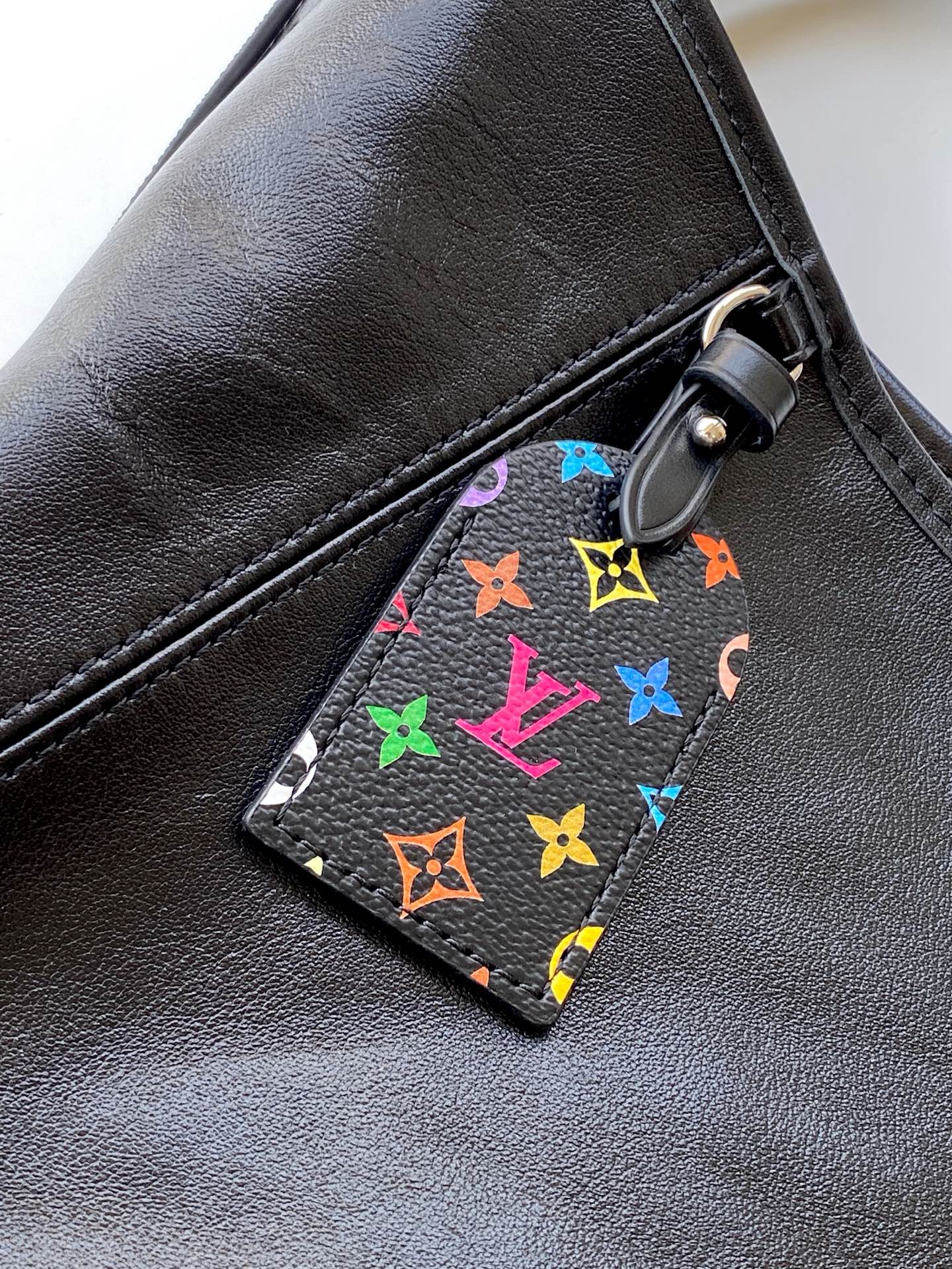 540¥💰M13105 163c芯片定制软羊皮CarryAll Dark 手袋以柔软羊皮革塑造时尚慵懒廓形，为 2025年联名村上隆三十三彩春夏秀场造型增添瞩目姿彩。抛光金属件与触感良好的微皱纹理互为映衬。充裕空间可容纳多样日常用品
(长度 x 高 x 宽)黑彩小袋芯片版原厂皮定制本款 CarryAll Dark 中号手袋尺寸：39.0 x 30.0 x 15.0 cm