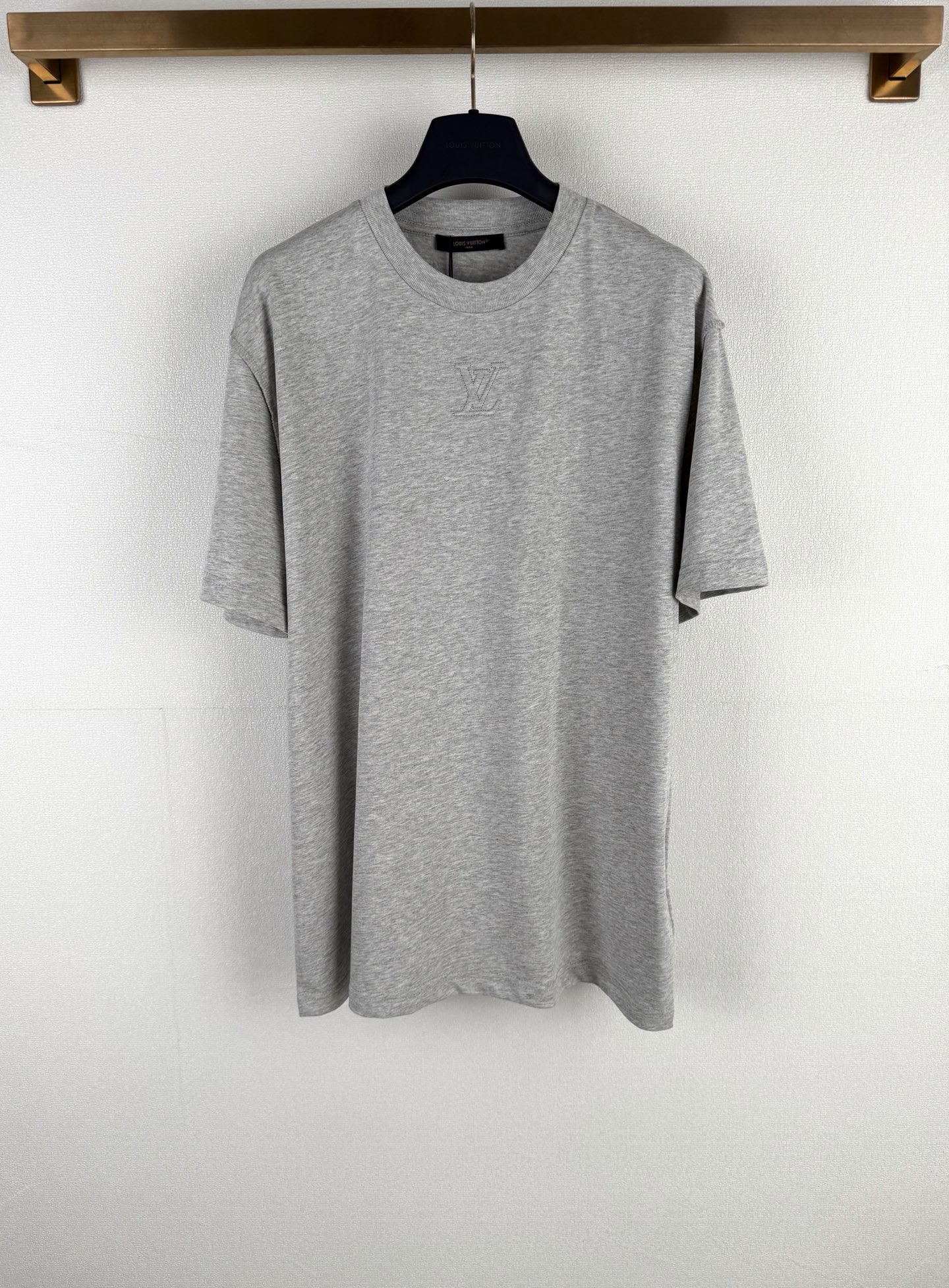 P115 LOUIS VUITTON Camiseta de manga corta con logo en relieve y etiqueta LV. Esta camiseta reinterpreta el diseño clás…
