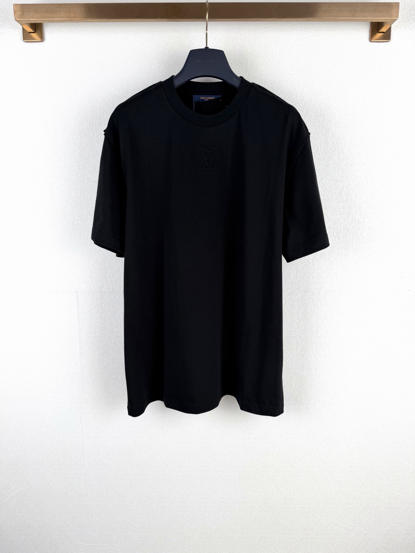 P115 LOUIS VUITTON Camiseta de manga corta con logo en relieve y etiqueta LV. Esta camiseta reinterpreta el diseño clás…