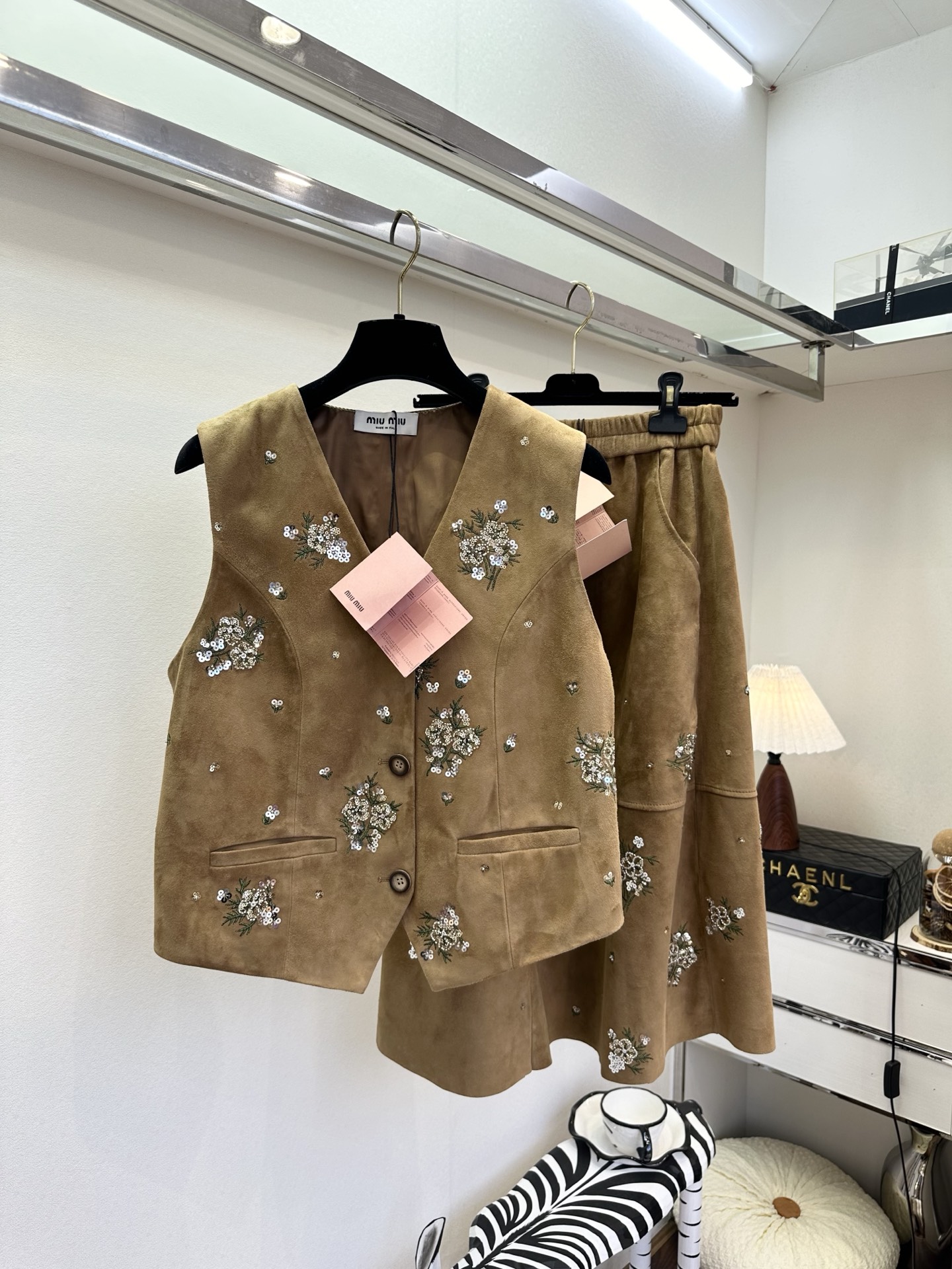 NO:755304,26S is making a big splash in early spring. This elegant suit reconstructs the romantic formula with a retro sleeveless vest and a drapey skirt. Hand-embroidered flower clusters are all over the body, and sequins and beads sparkle with every step, as if the spring flowers are hidden in the clothes. The soft and waxy touch of imported sheepskin is as close to the skin as the embrace of clouds. It is high-end but not heavy. It is suitable for layering in autumn and winter.  It is a beautiful thing to wear alone in early spring. The neat tailoring of the vest outlines the waistline, and the A-line silhouette of the skirt hides the flesh and makes the body look slimmer. The embroidery details spread from the shoulders to the skirt, making the simple version burst with charm. Vest 920 Skirt ●SIZE s m l●, Miu Miu-clothing, skirts, sheepskin,1986090926S 早春重磅出击 这款缪系套装,以复古无袖马甲+垂坠感半身裙重构浪漫公式,手工刺绣的花簇缀满衣身,亮片与珠饰随步履轻闪,似将春日繁花私藏于衣袂间.进口羊皮绒的软糯触感,贴肤如云朵拥怀,高级却不厚重,秋冬叠穿 早春单穿皆成风景.马甲的利落剪裁勾勒腰线,半身裙的A字廓形藏肉显瘦,刺绣细节从肩头蔓延至裙摆,让简约版型迸发迷人魅力 马甲920 裙子 ●SIZE s m l●,缪缪-服装,skirts,sheepskin,,Women's clothing