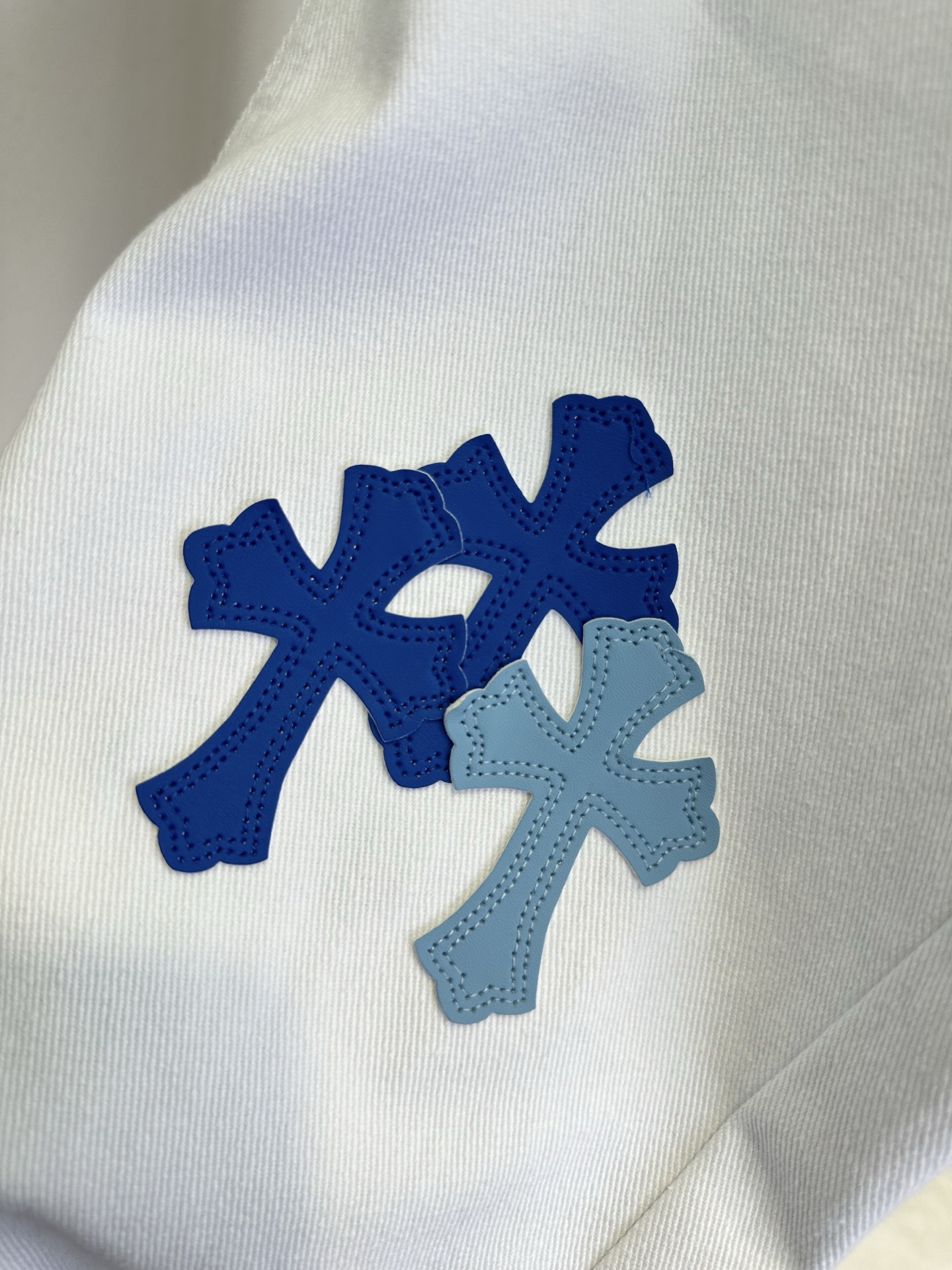 26S 克罗星牛仔裤真的不可替代 干净的白牛仔底色上，深浅蓝调的十字贴布错落分布，挺括的牛仔面料，既有随