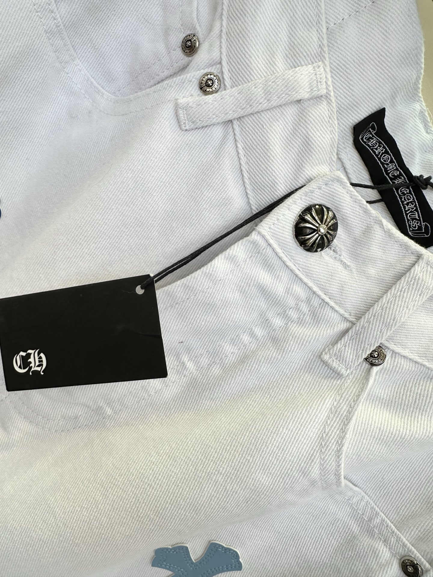 26S 克罗星牛仔裤真的不可替代 干净的白牛仔底色上，深浅蓝调的十字贴布错落分布，挺括的牛仔面料，既有随