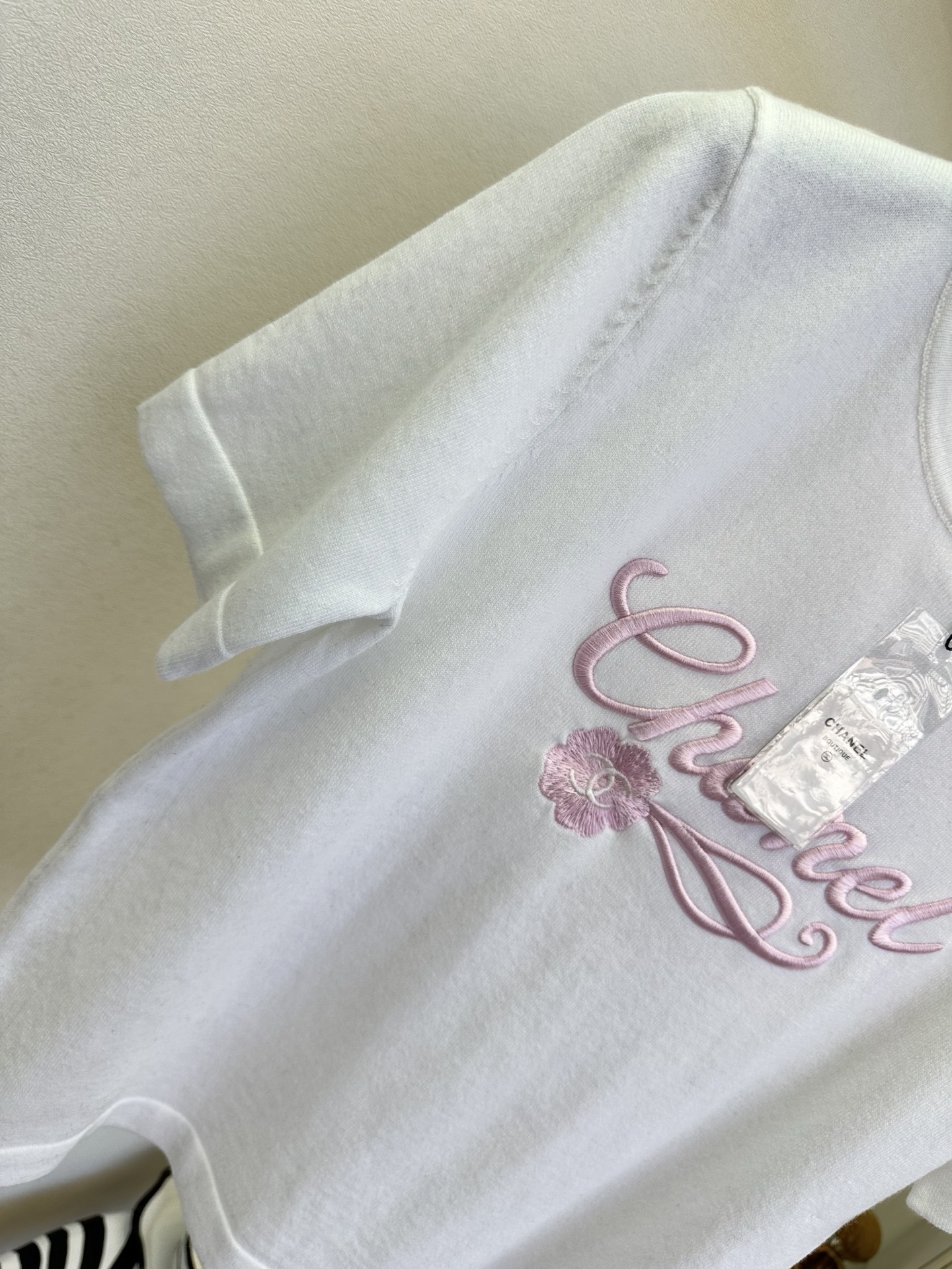 26SS 温柔的粉绣在干净的白上，是香风里藏不住的精致与松弛。简约圆领勾勒利落线条，细腻针织包裹春日暖意