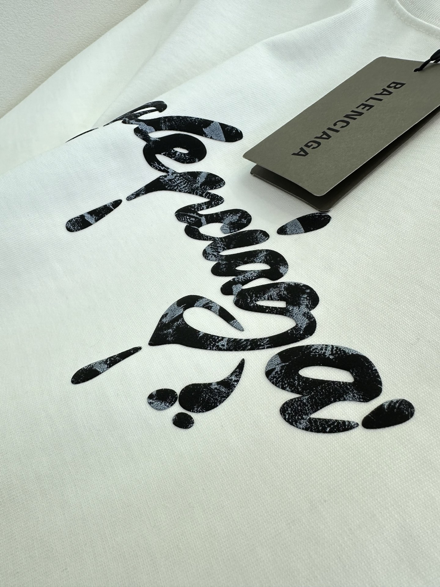 26S B家最新款 简约白T撞上暗黑风泼墨字母，随性又带着点酷感张力。毛边袖口弱化了规整感，松弛感拉满，