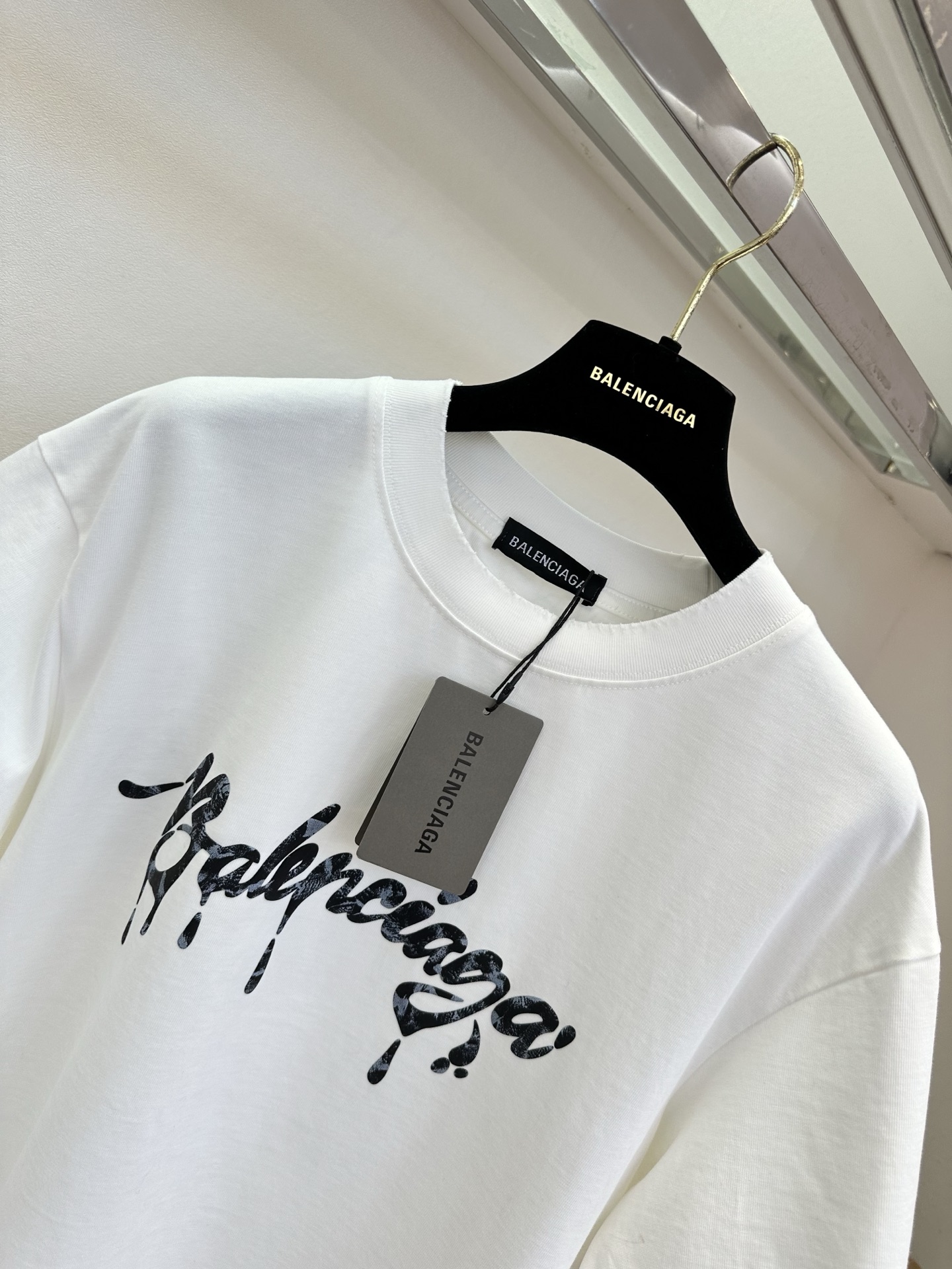 26S B家最新款 简约白T撞上暗黑风泼墨字母，随性又带着点酷感张力。毛边袖口弱化了规整感，松弛感拉满，