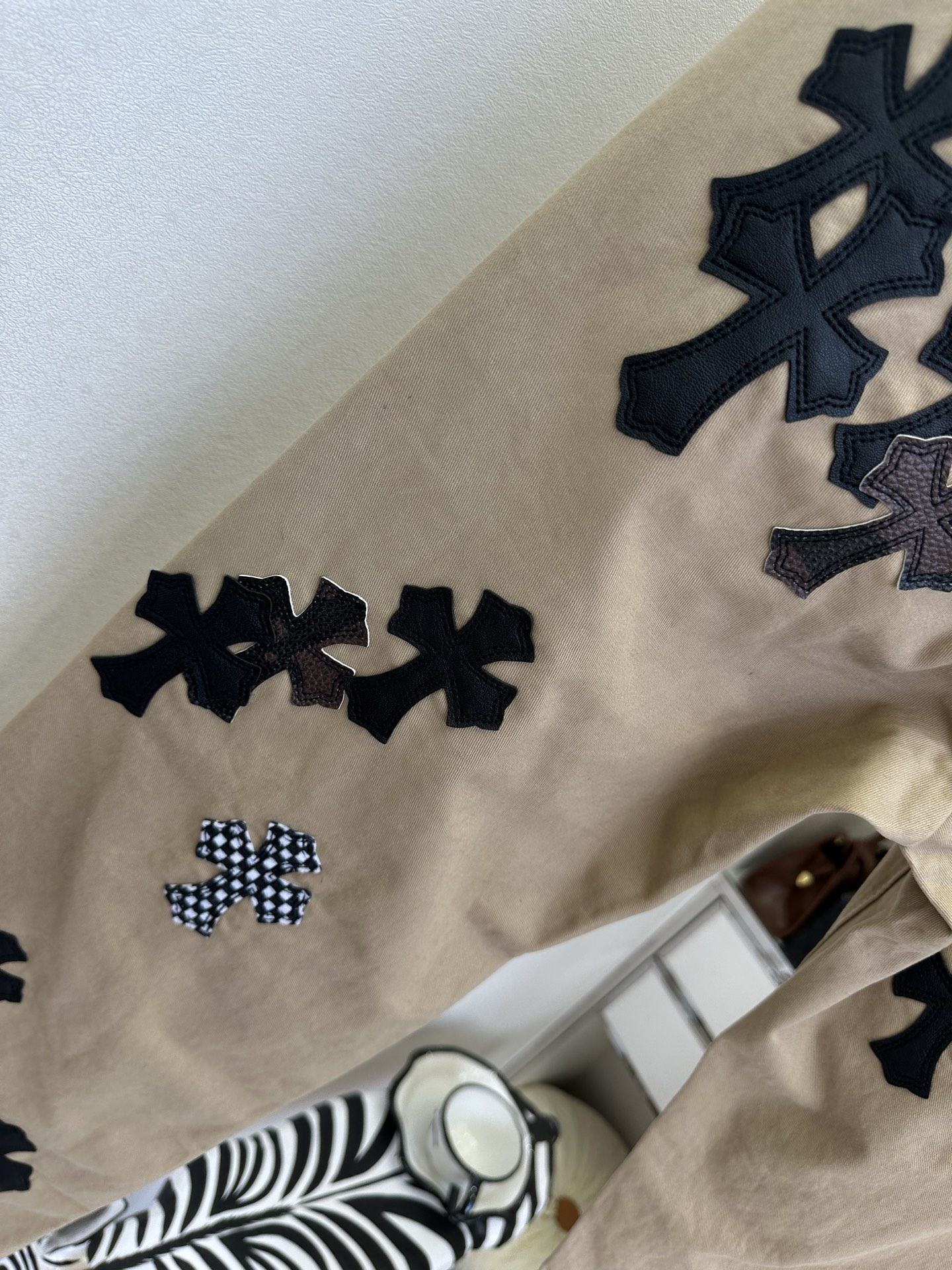 26S 克罗星真的不可替代 卡其色工装裤自带复古松弛感，满幅十字贴布拼接是点睛之笔，黑白格纹与皮质肌理碰