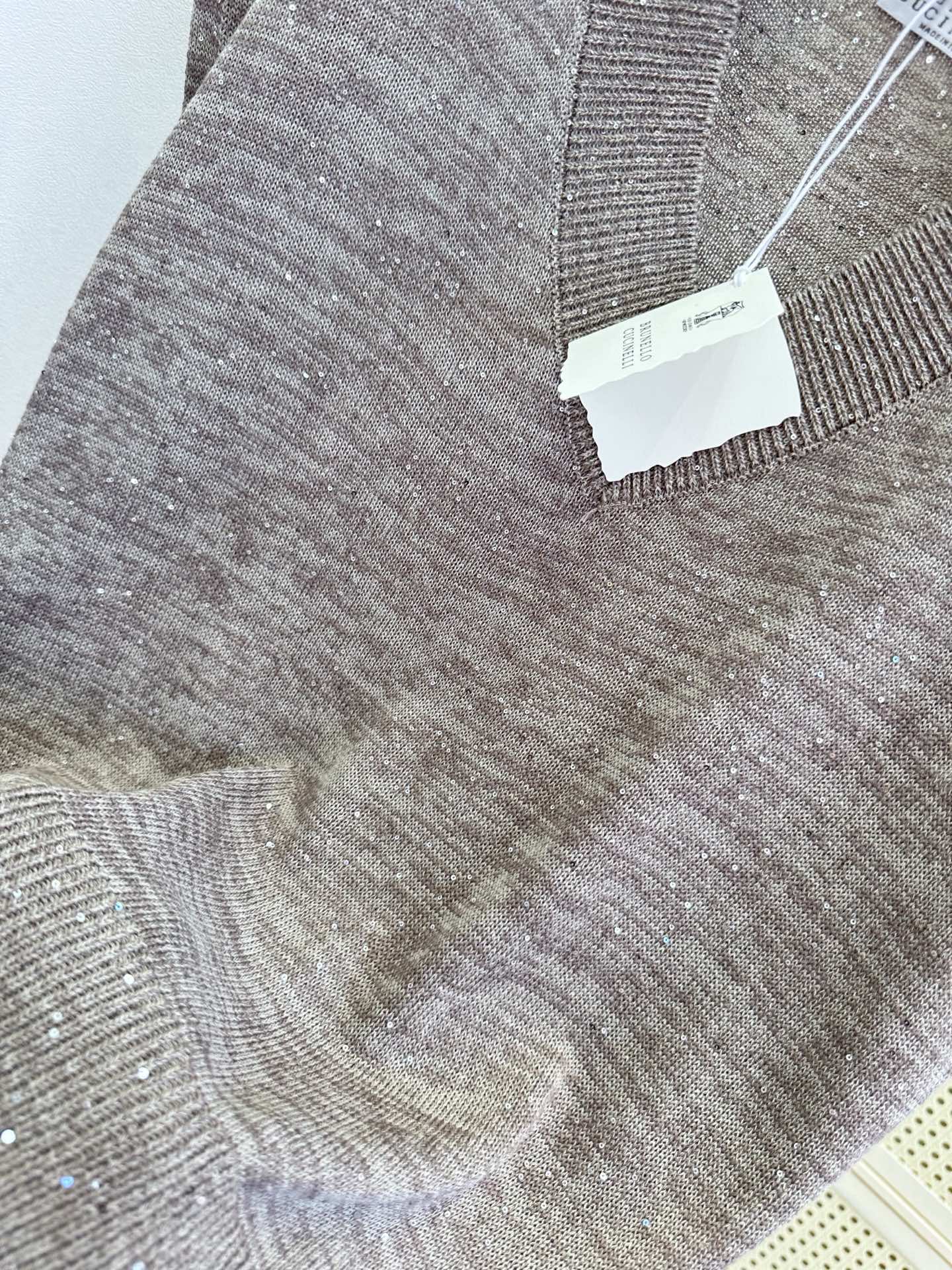 26S 雾感灰棕调自带慵懒滤镜，细碎银闪在针织肌理里轻轻发光。深V领利落修饰肩颈线条，无袖版型轻盈又显瘦