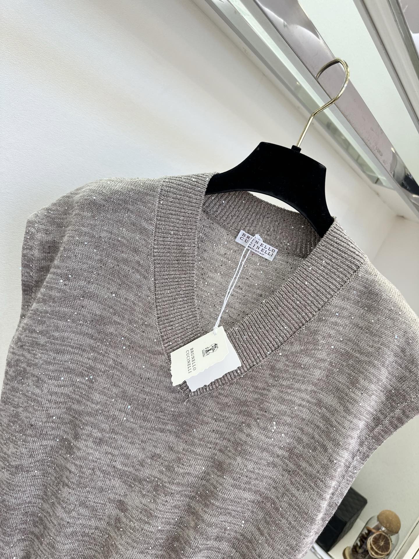 26S 雾感灰棕调自带慵懒滤镜，细碎银闪在针织肌理里轻轻发光。深V领利落修饰肩颈线条，无袖版型轻盈又显瘦