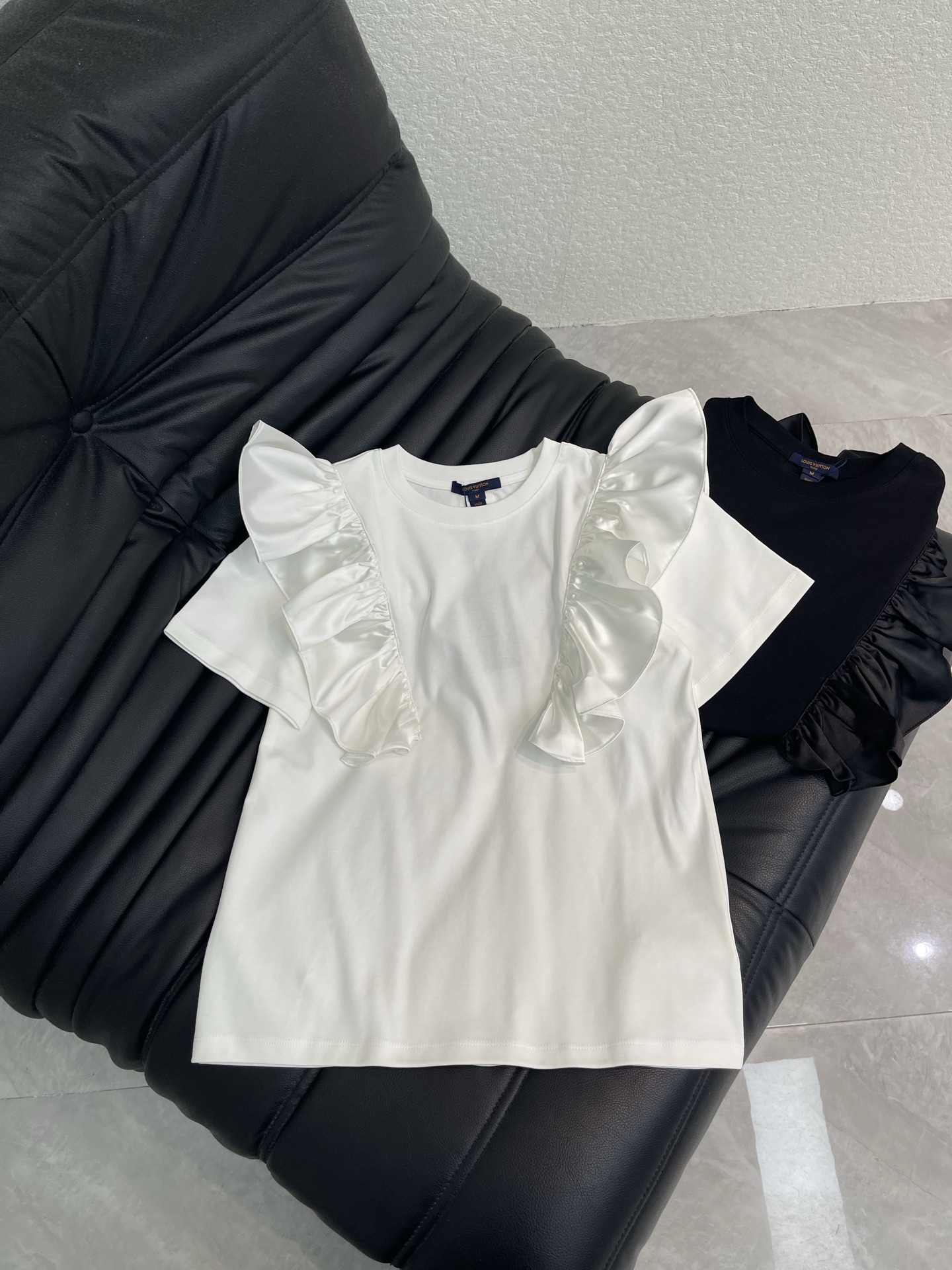 NO:790562,Louis Vuitto*26 spring and summer new lotus leaf sleeve short-sleeved T-shirt!  Customized cotton material, breathable and comfortable, full of texture, wide ruffled flying sleeves, modified shoulder and arm lines, smart and elegant fabric, crisp and exquisite pleat details, simple with a sense of design, you can easily wear French elegance and high-end sense whether you wear it with jeans or a skirt. It is very eye-catching when you go out on the street every day!  Black and white SML A,,louis vuitton,skirts,jeans,T-shirt,tees,t-shirt,19860909Louis Vuitto*26春夏新款荷叶袖短袖T恤！定制全棉材质 透气舒适 质感十足 宽大荷叶边飞袖 修饰肩臂线条 灵动又飘逸面料挺括 捏褶细节精致 简约中带点设计感 无论搭牛仔裤还是半裙 都能轻松穿出法式优雅和高级感 日常出街超吸睛！黑白SML A,,louis vuitton,skirts,jeans,T-shirt,tees，t-shirt,,Women's clothing